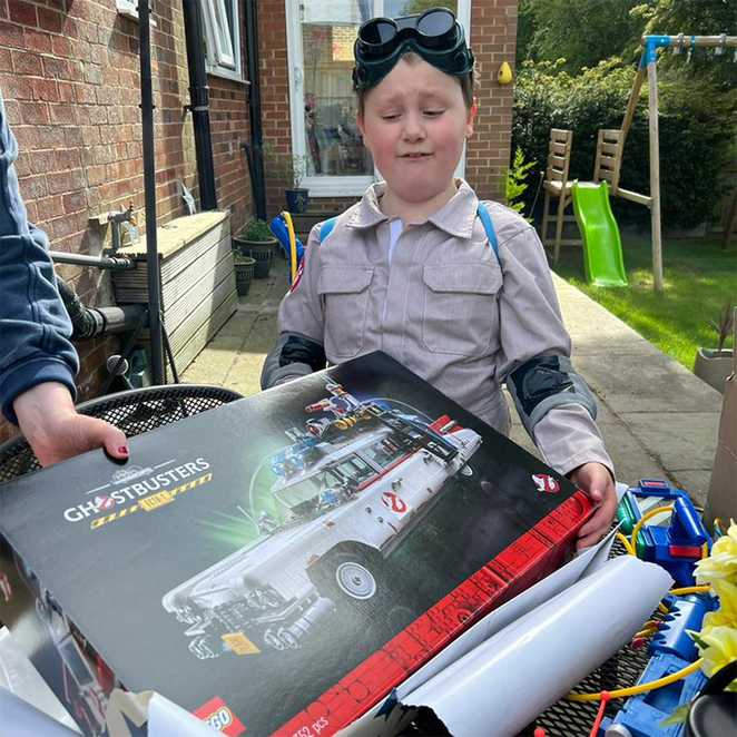 George receiving a LEGO Ecto 1 model as part of his wish to be a Ghostbuster.