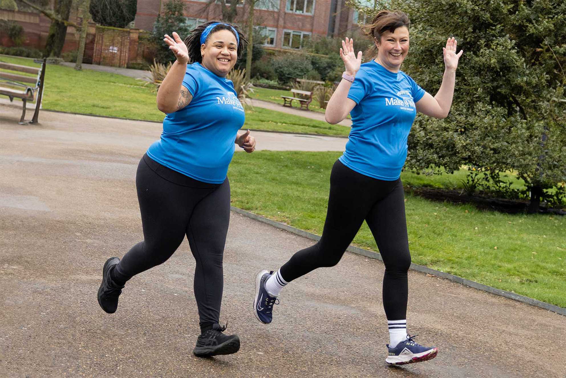 Charlotte and Alecia running through the park in their blue Make-A-Wish t-shirts.