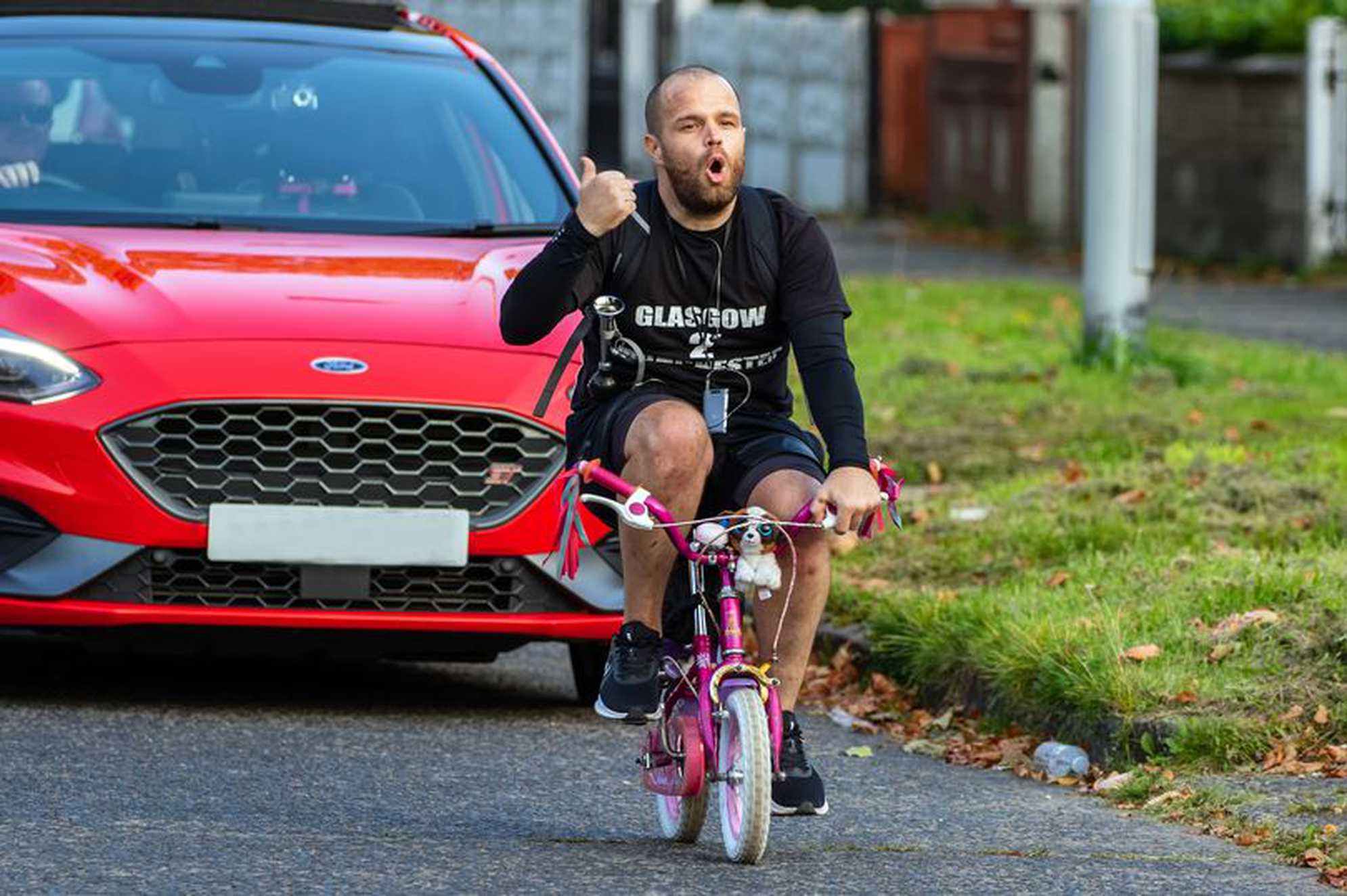 Wesley Hamnett on his daughter's bike during his cycling challenge.