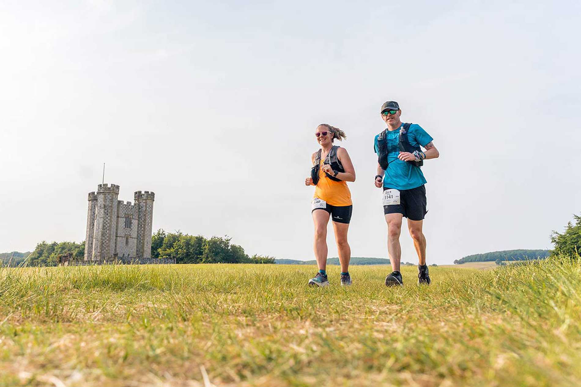 Two runners passing by a folly as they take on the Race to the King challenge.