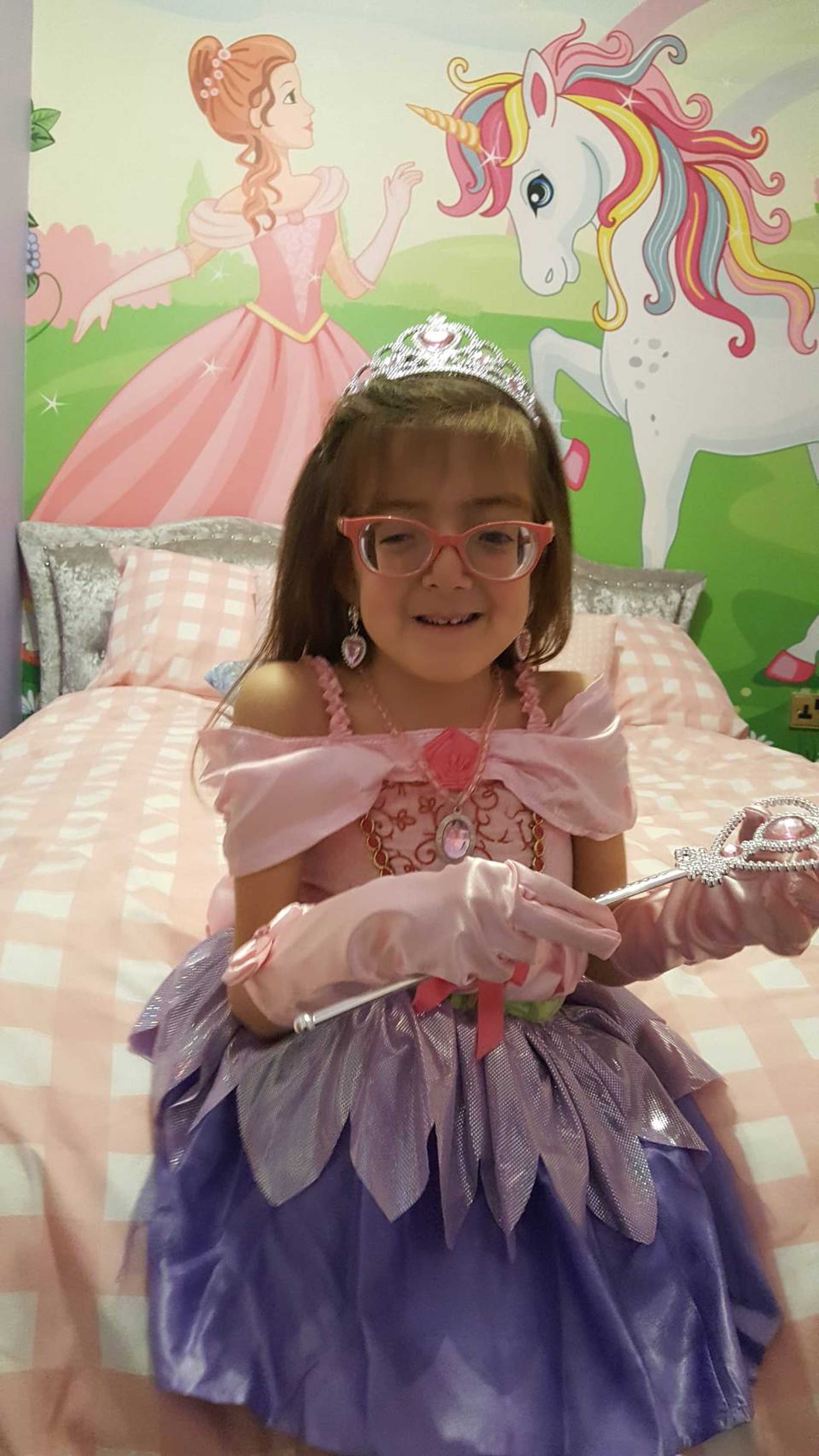 Smiling wish child, Tiara in her princess-themed bedroom.