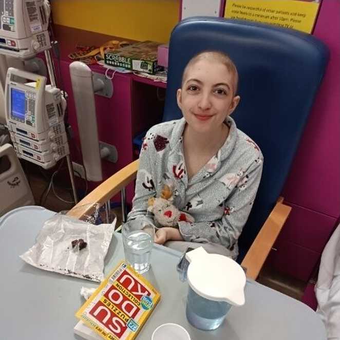 Ellie sat up in a chair during her treatment in hospital.