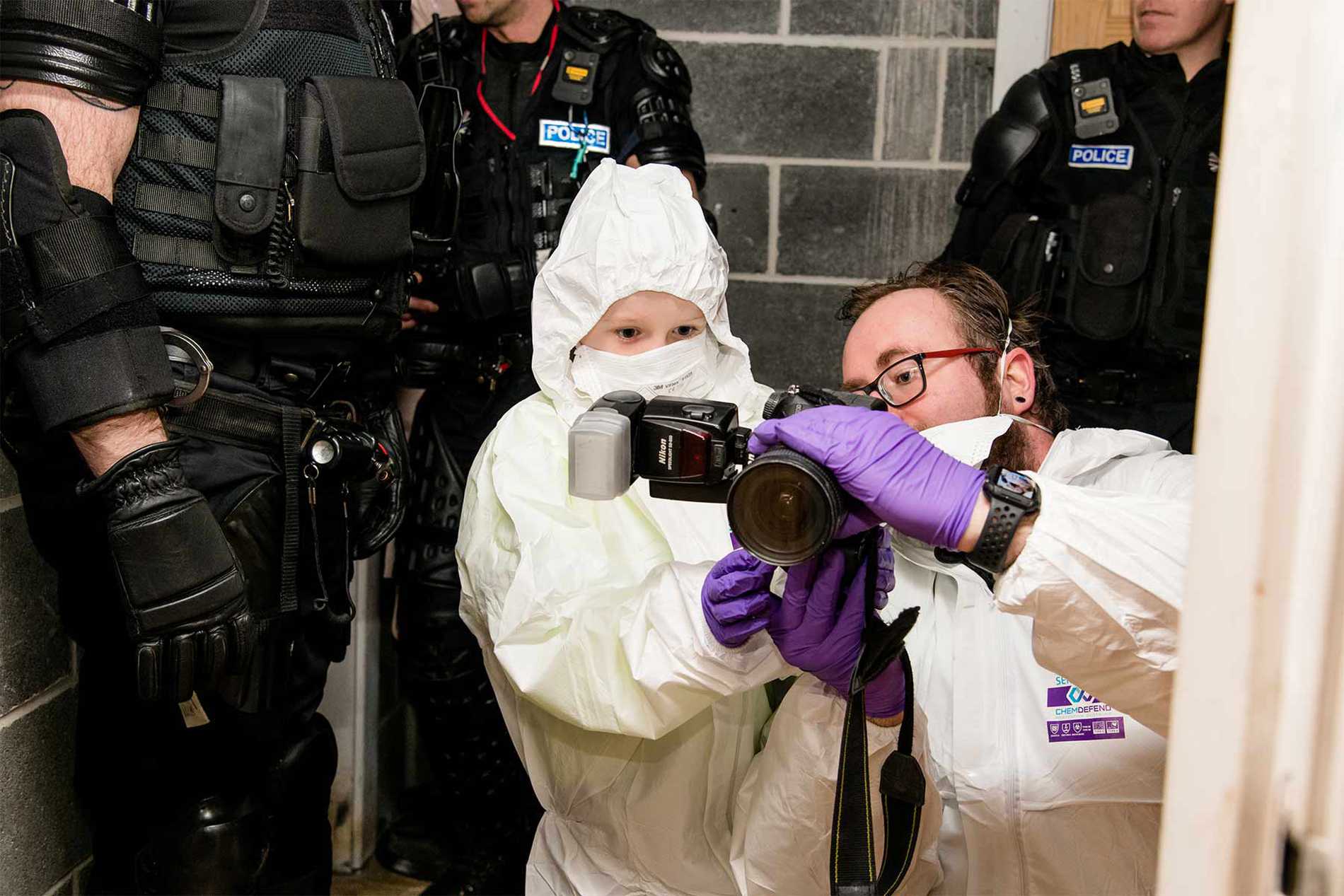 Allan taking photos of the crime scene with a scenes of crime officer.