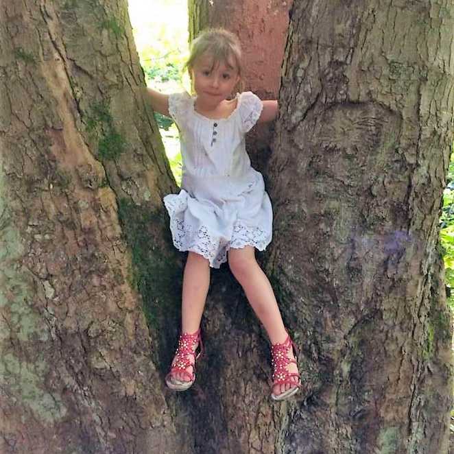 Amber climbing a tree before she was diagnosed with Batten disease.