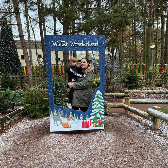 Charlotte and her mum posing in a 'Winter Wonderland' festive selfie frame.