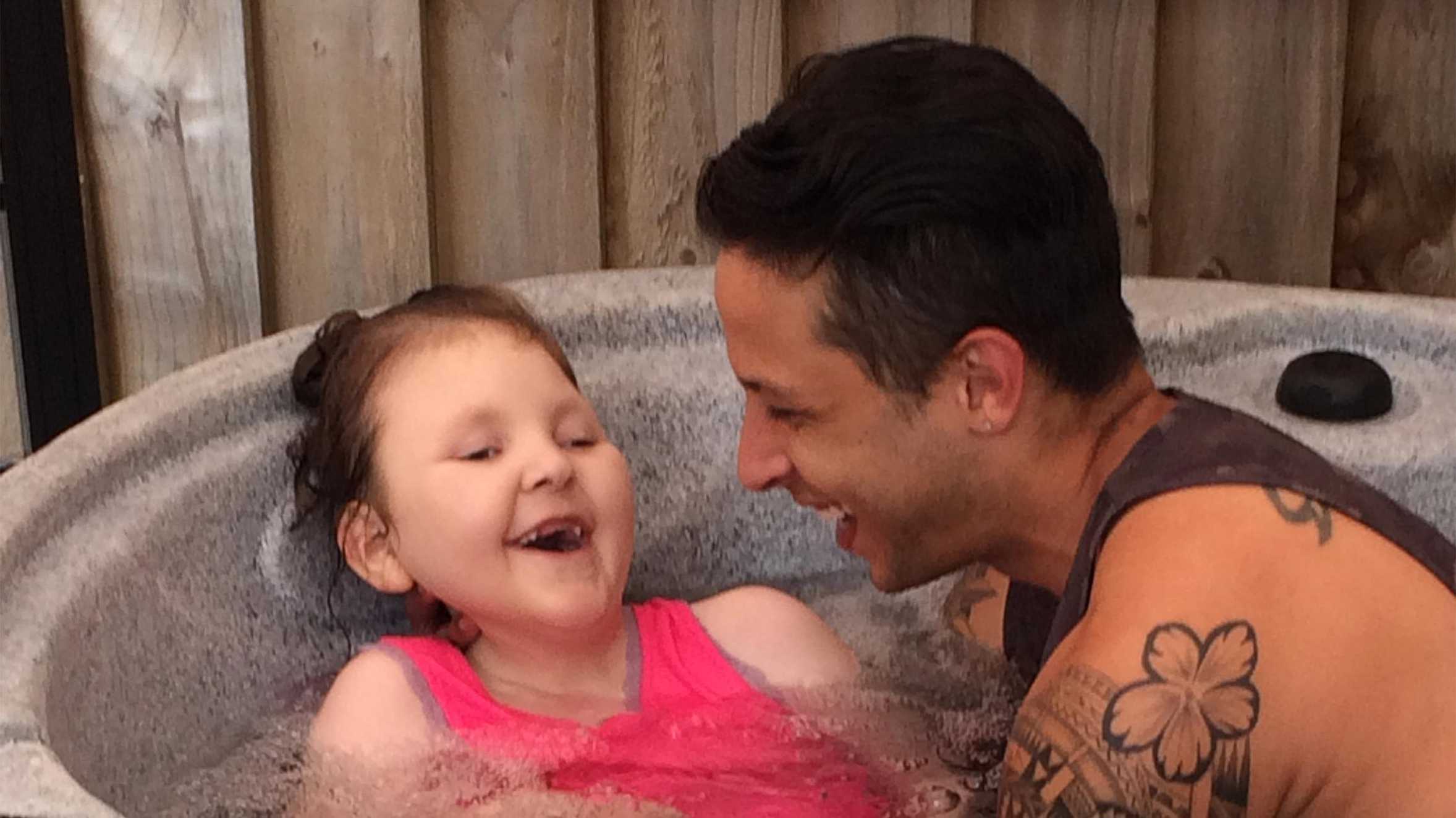 Casey smiling with her dad in the spa pool