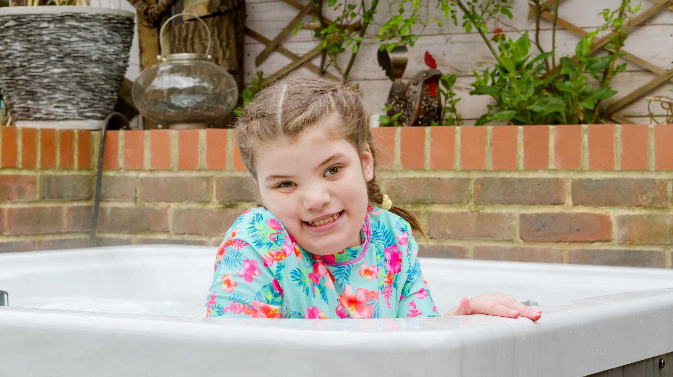 Wish child, Gracie, smiling in her new hot tub.
