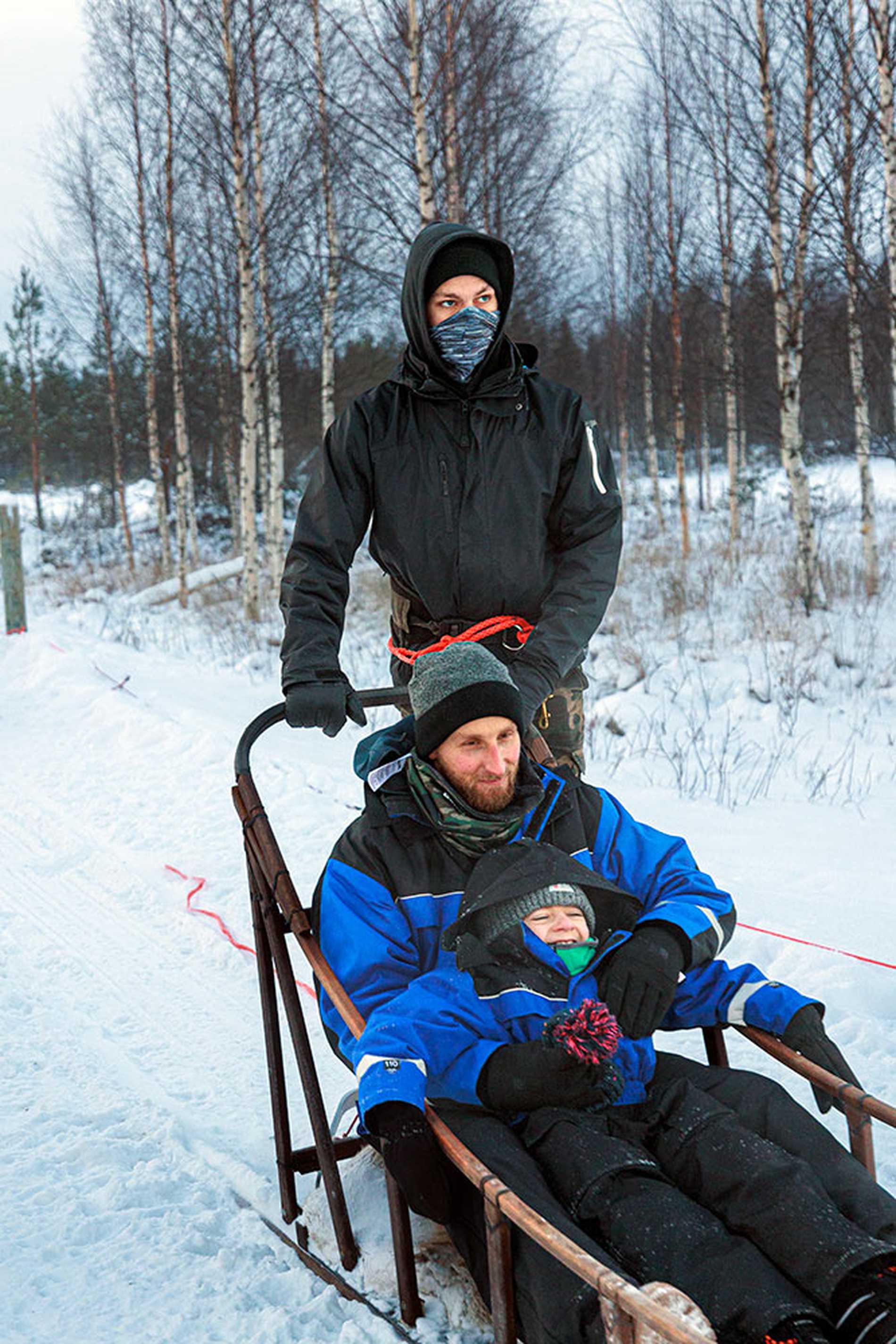 A close up of dad and one of the children on a dog sled ride.