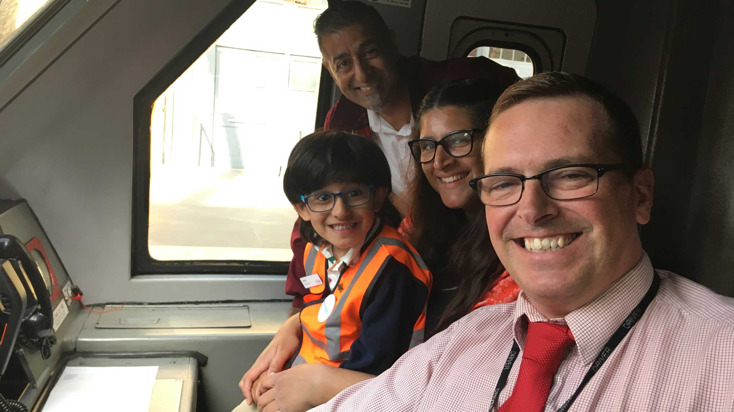 Arjun with his mum and dad and a member of Virgin staff, inside the train