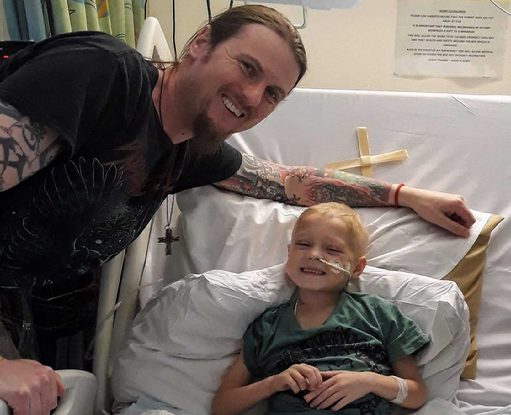 Zakk smiling in his hospital bed during a visit from his dad.