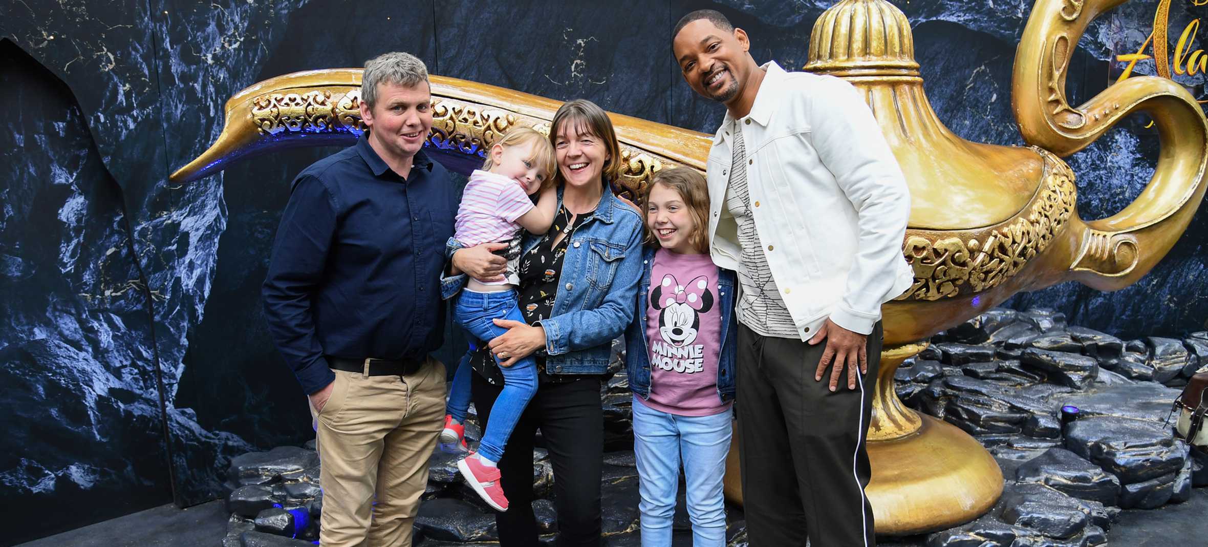 Emily and her family with Will Smith next to Aladdin's lamp