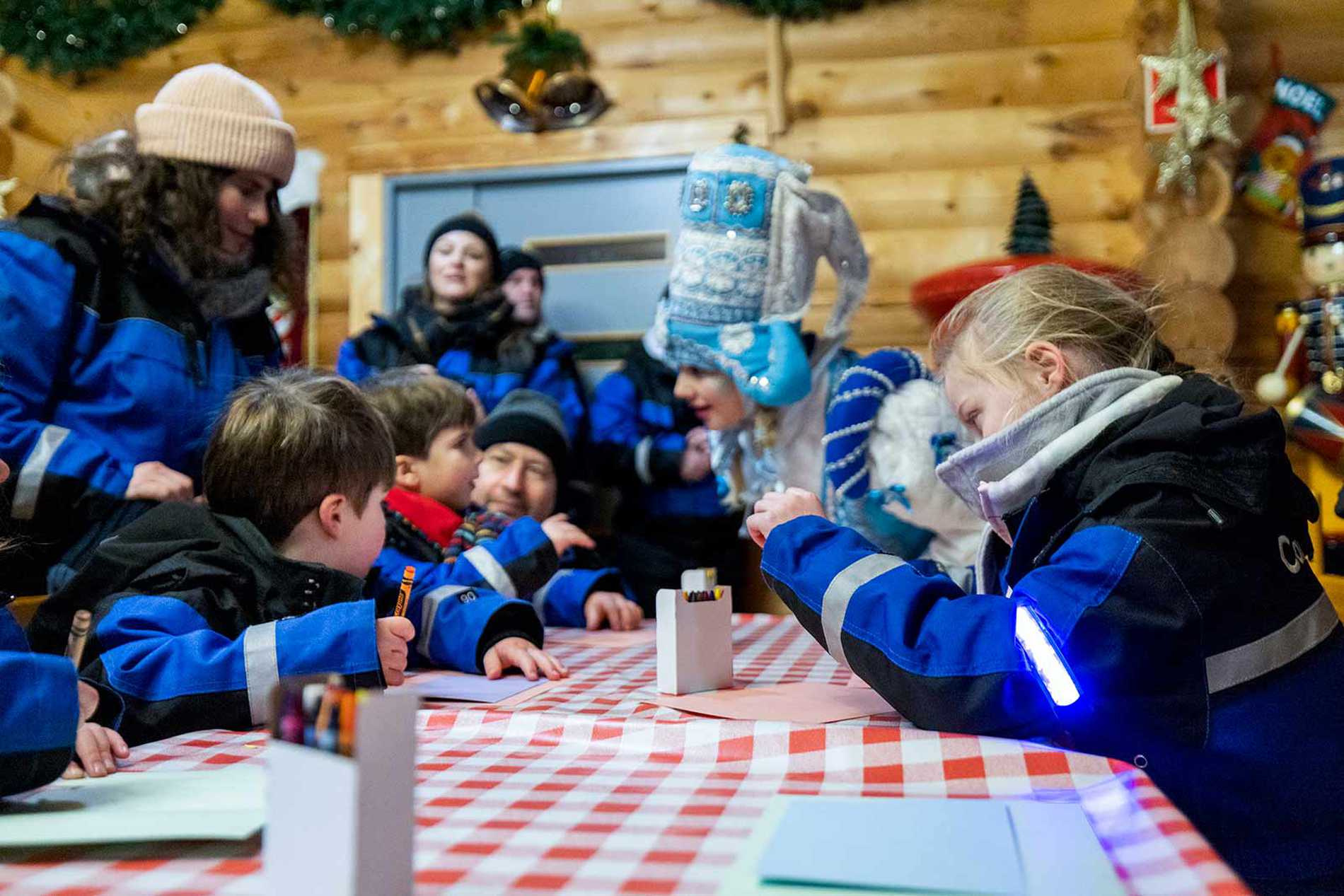 Alice sat at a table with other wish children, writing a letter to Santa.