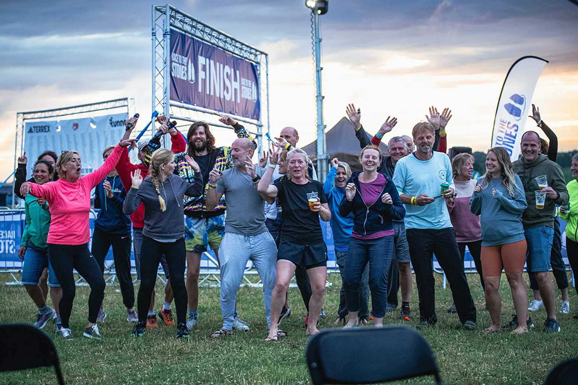A group of participants celebrating together by the finish line after completing the Races to the Stones challenge.