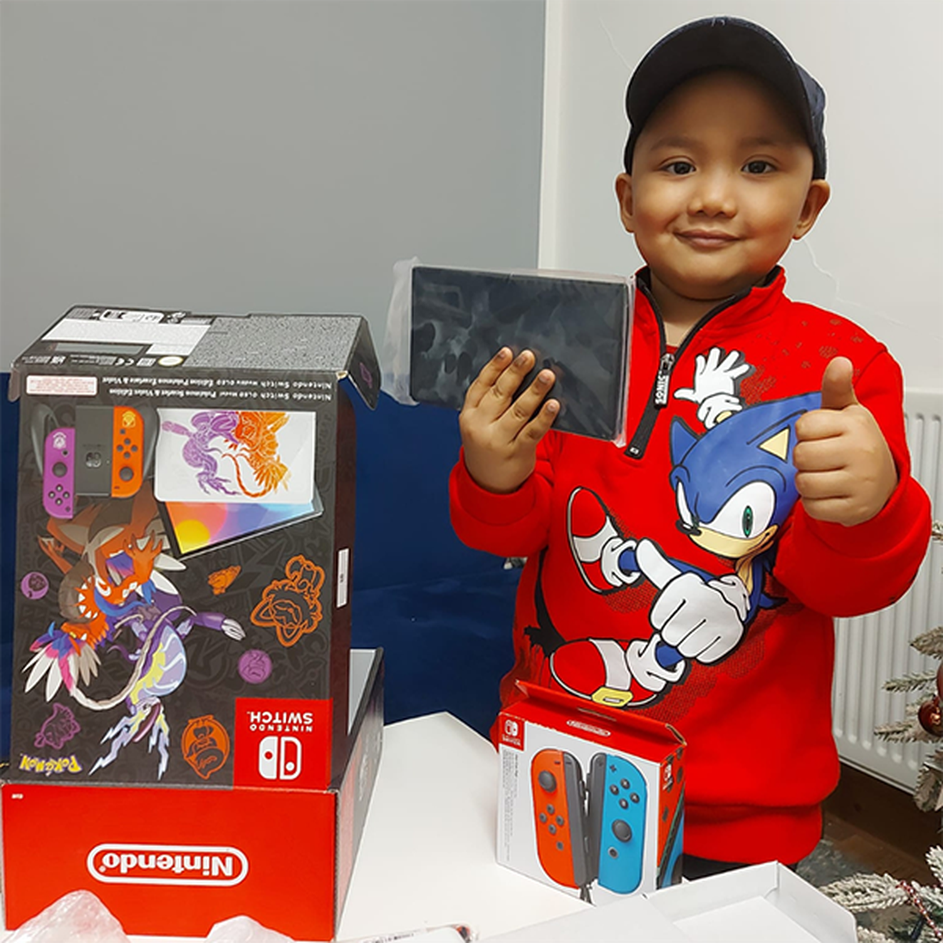 Sevi smiles and puts a thumb up as he holds his Nintendo Switch