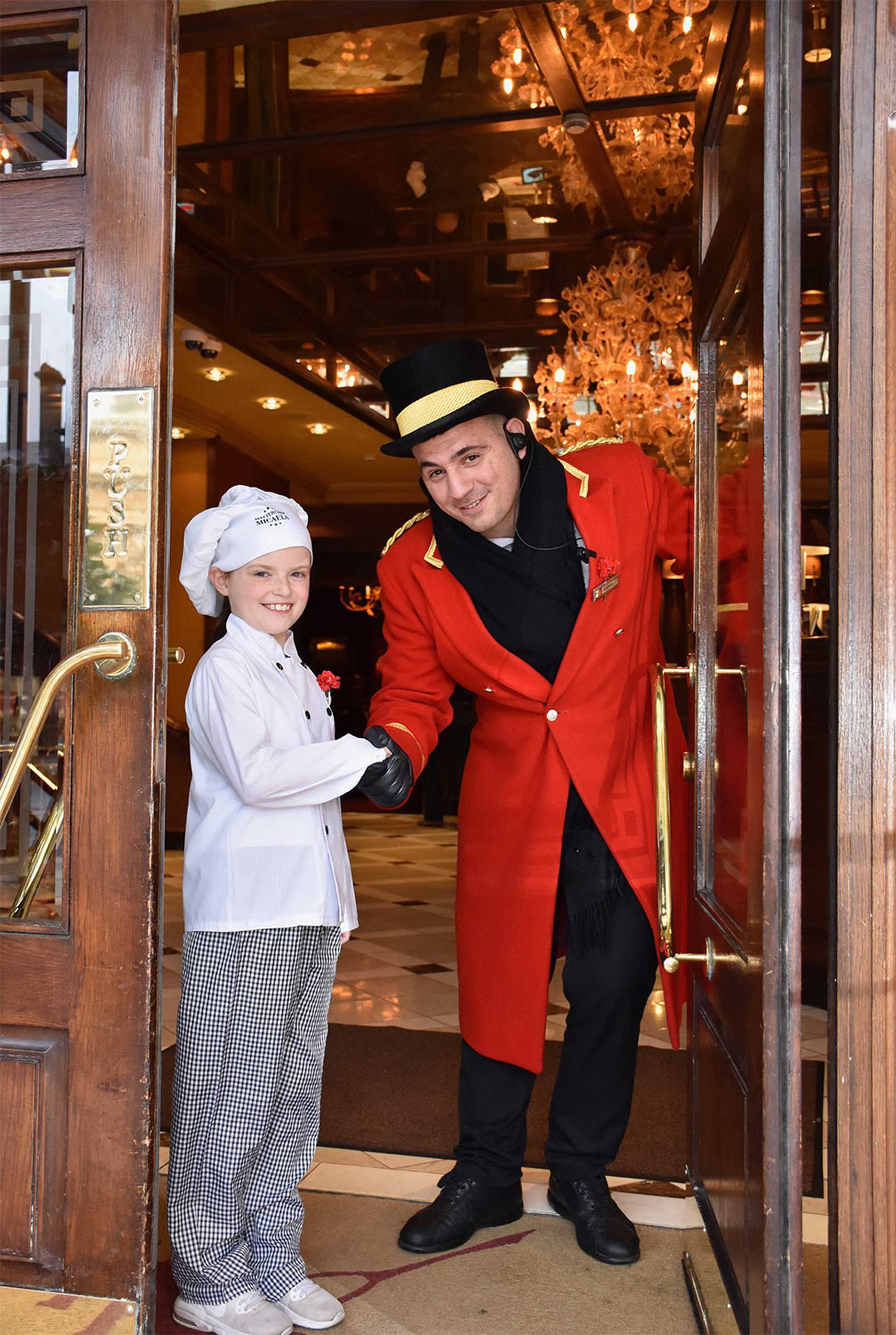 A smiling Micaela shaking the hand of a Reubens Hotel Doorman.