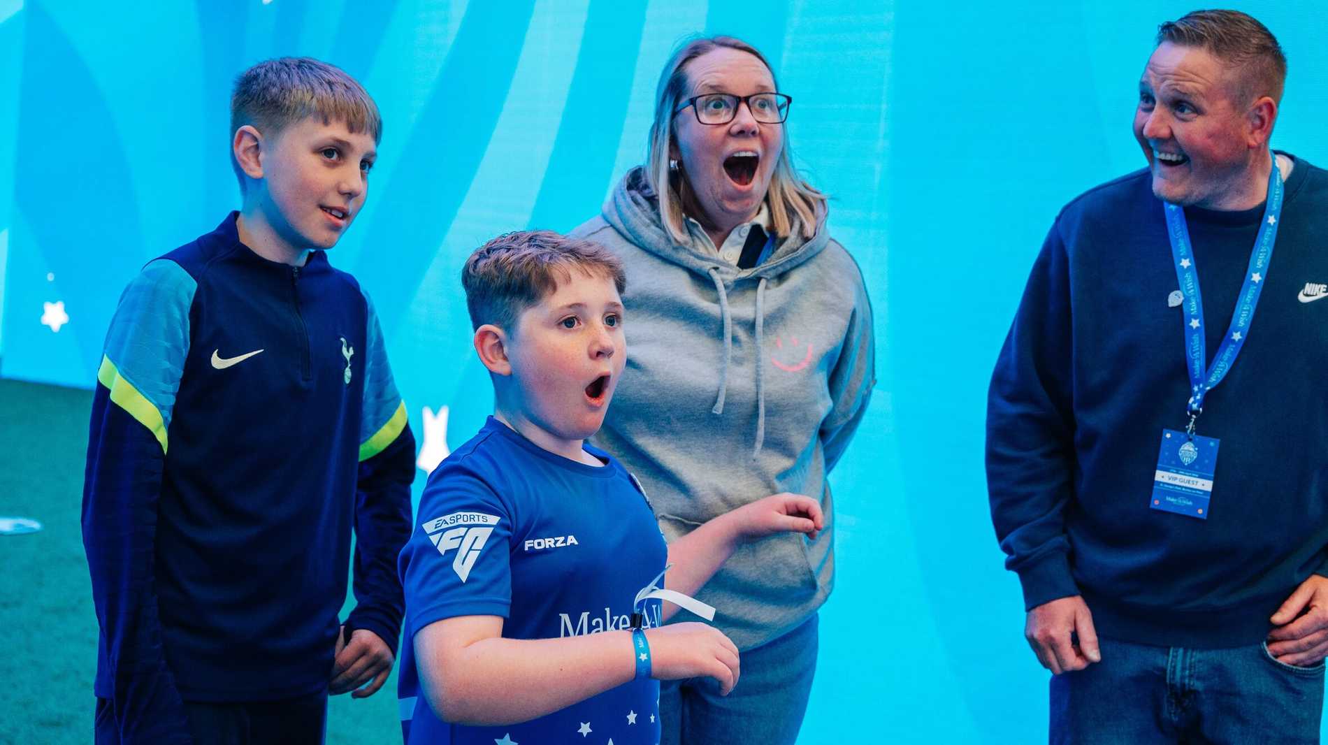 A young boy has a look of excitement and wonder on his face.  Behind him a lady is stood open mouthed in astonishment.