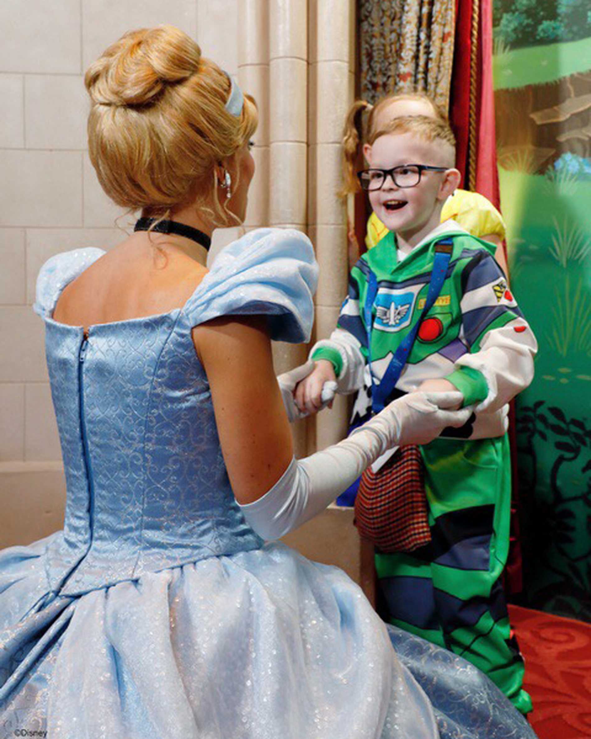 Patrick, dressed as Buzz Lightyear, with a big smile as he meets a Disney princess.