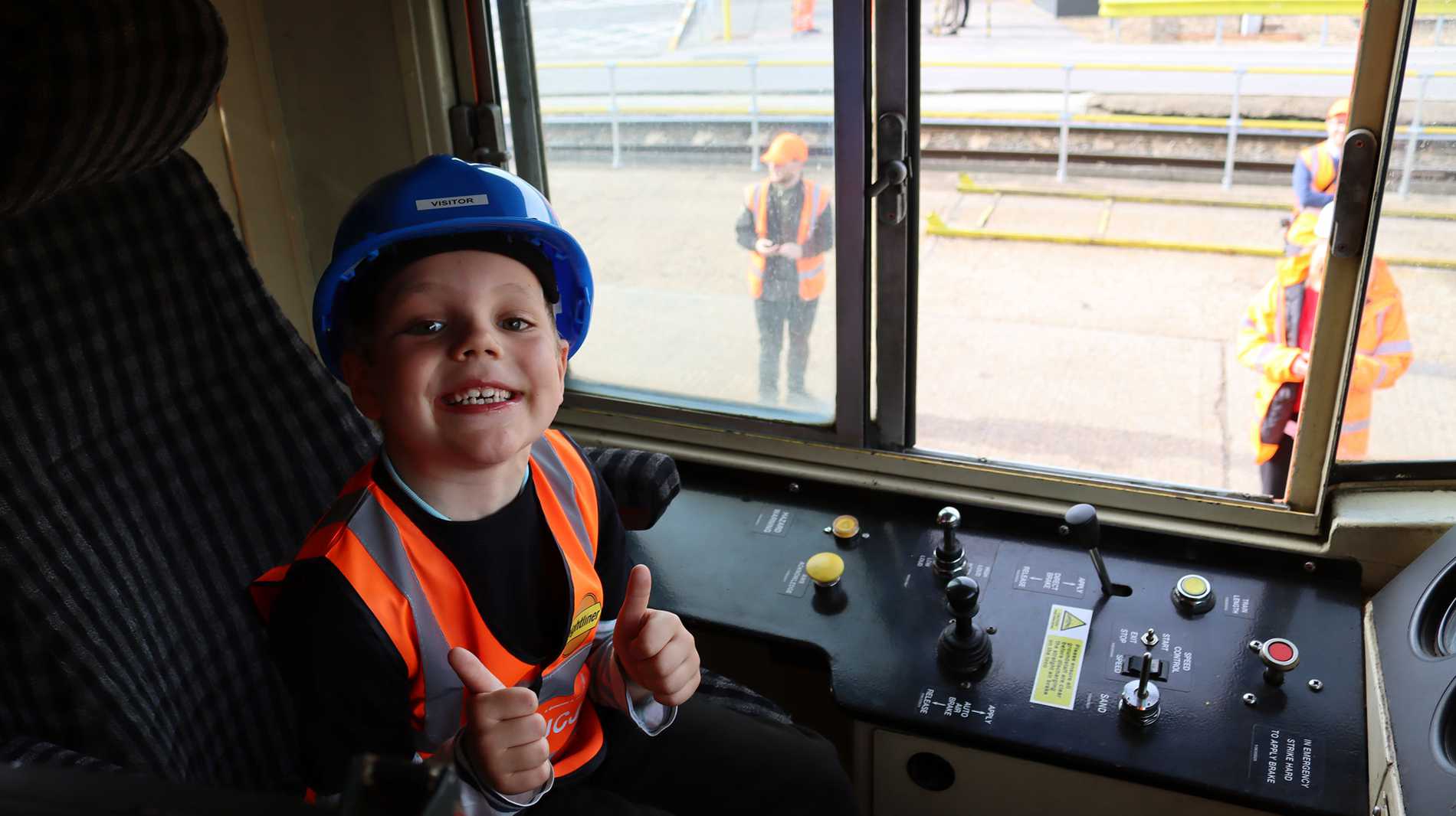 Josiah smiling as he sits at the controls of the freight train during his wish.
