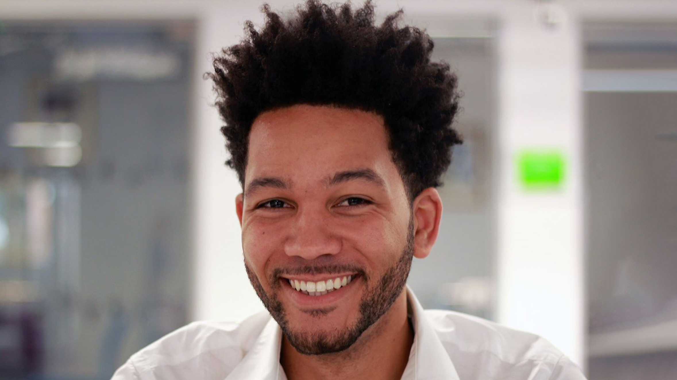 A close up of Anthony in a white shirt, smiling to the camera.