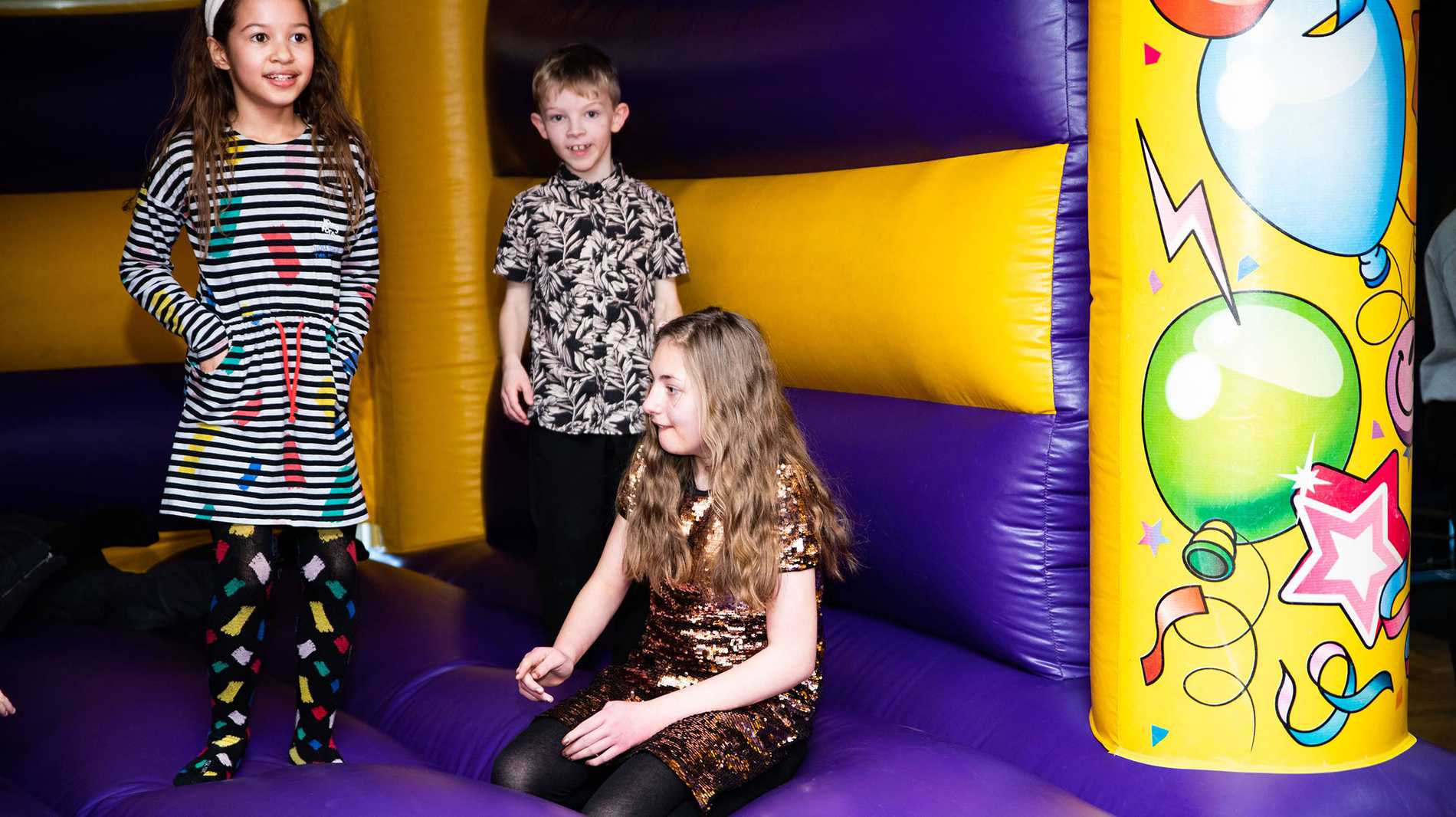 Eloise and her friends playing on the bouncy castle.