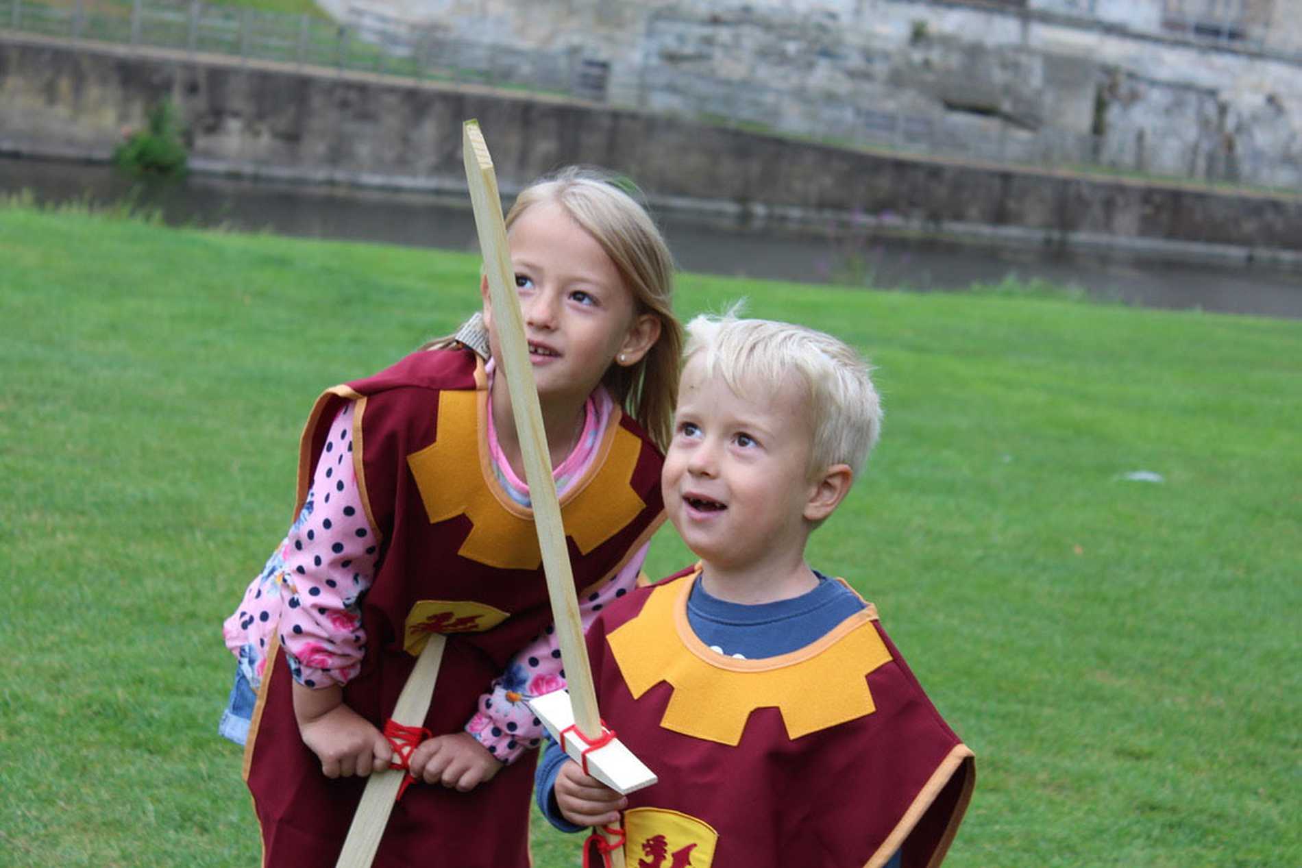 Hunor and his sister, Dorka dressed as knights and holding their swords.