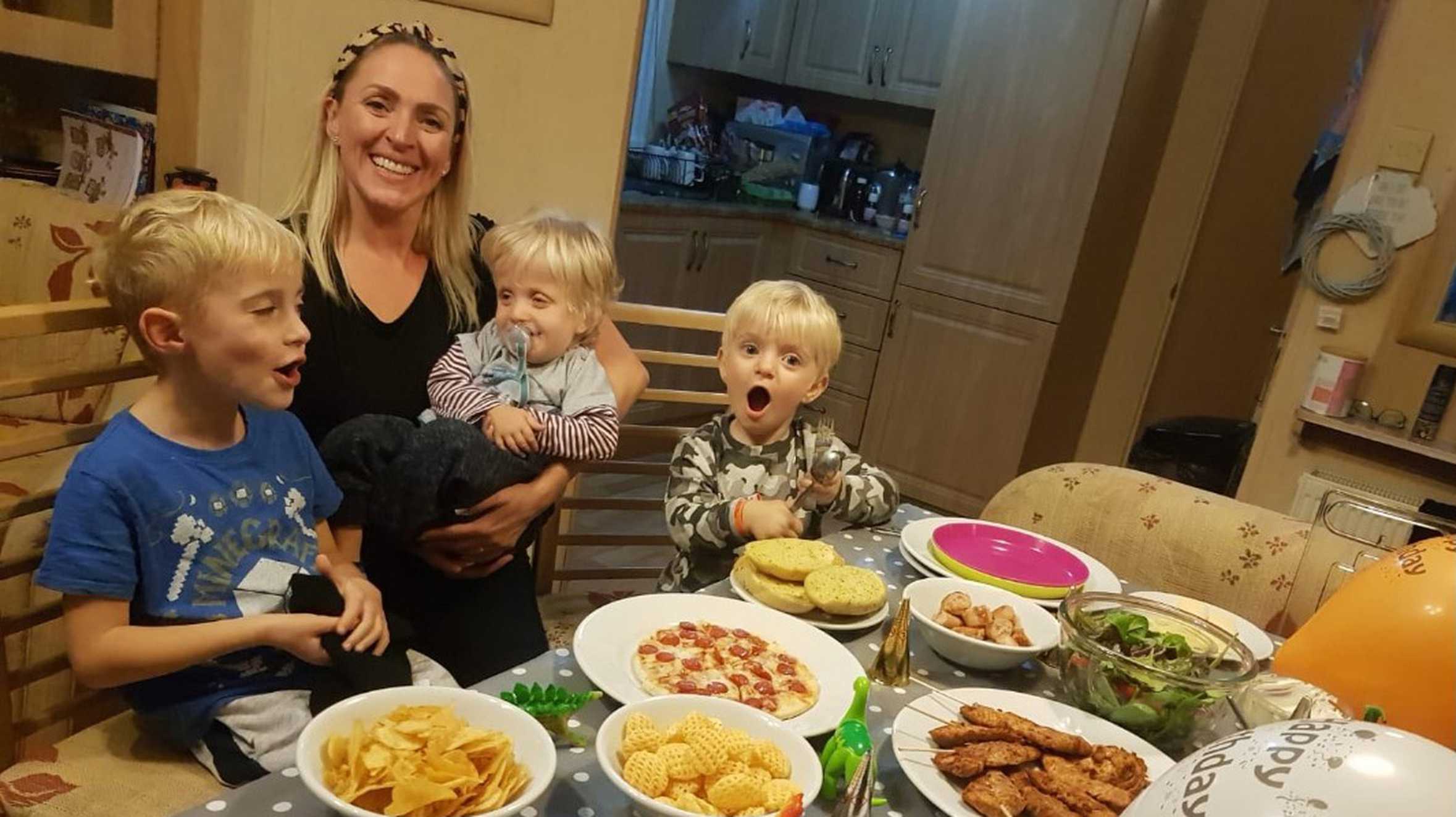 Ezra and family sitting around table of food