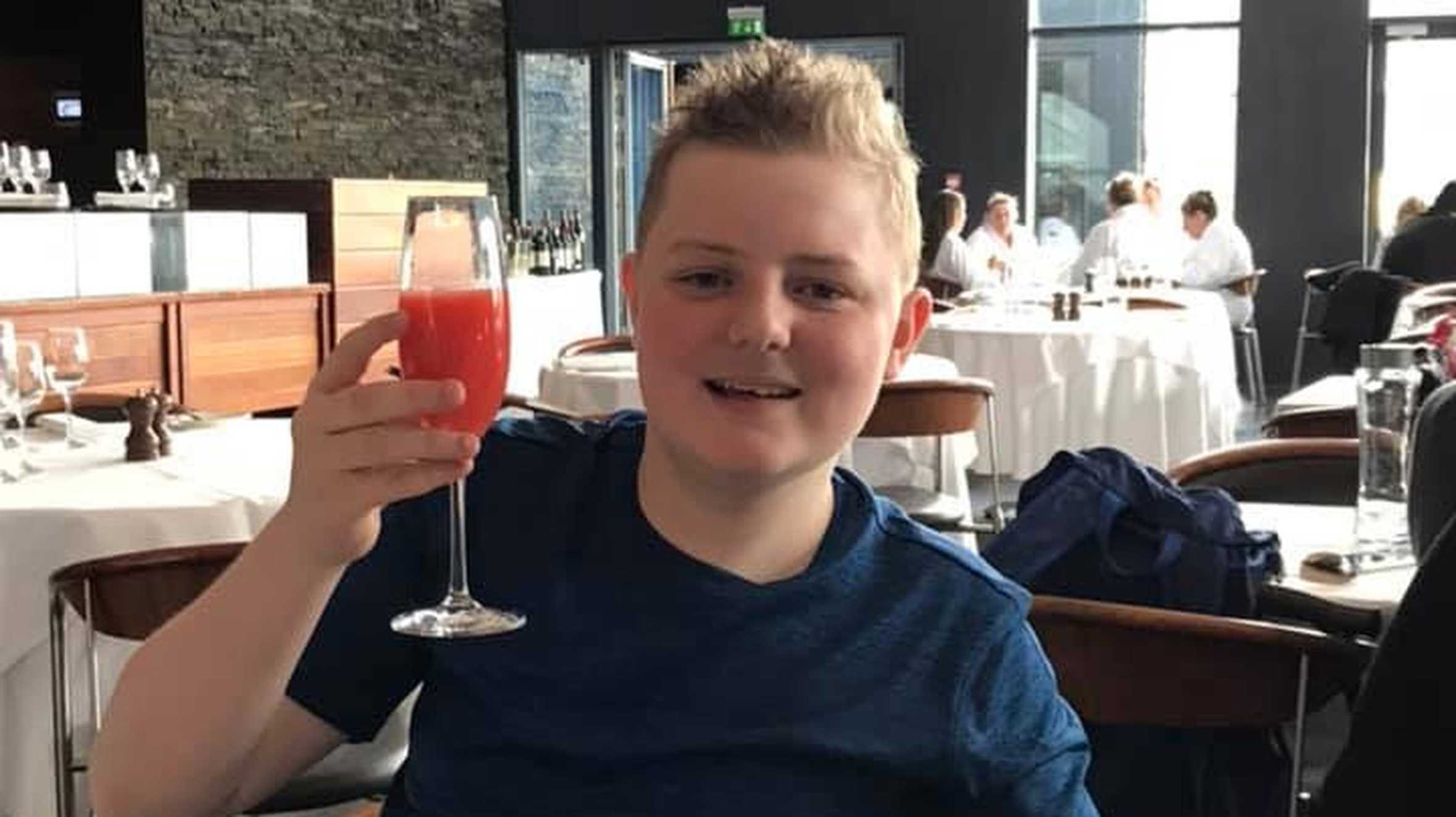 Adam smiling holding up a drink