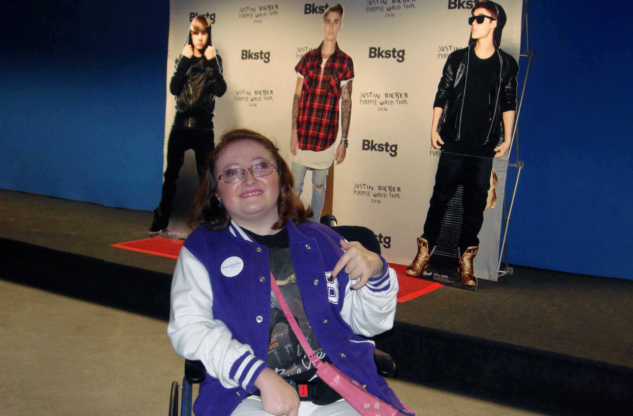 Imi in front of some life-sized posters of Justin Bieber, during her wish to meet the singer.