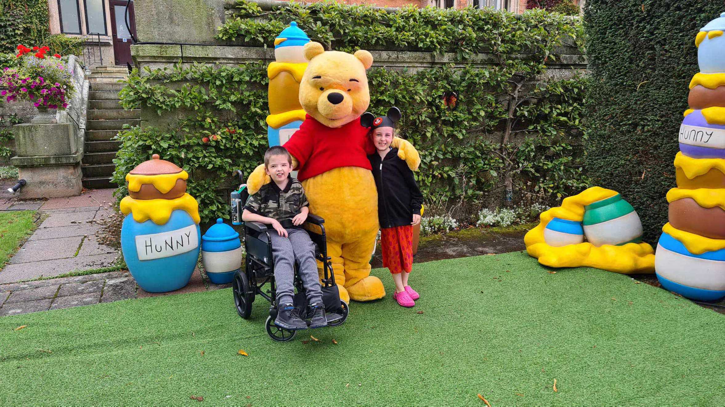 Lewis and Lily-Grace posing with Winnie the Pooh.