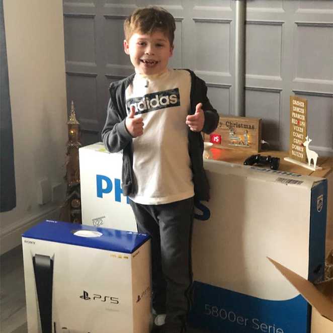 Mikey giving a thumbs up next to his new PS5 games console.