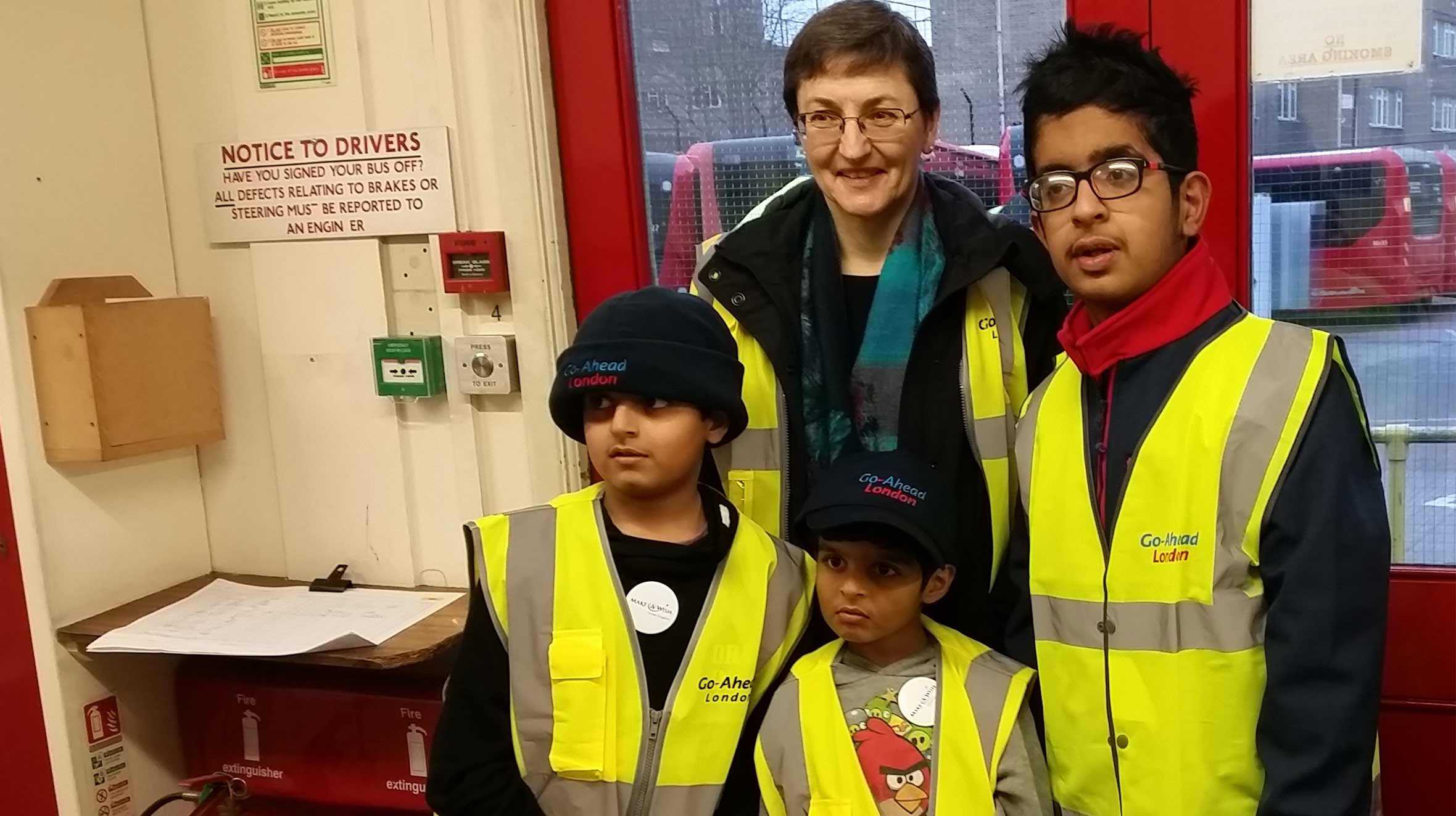 Krish and his brothers wearing high visibility jackets at the bus station.
