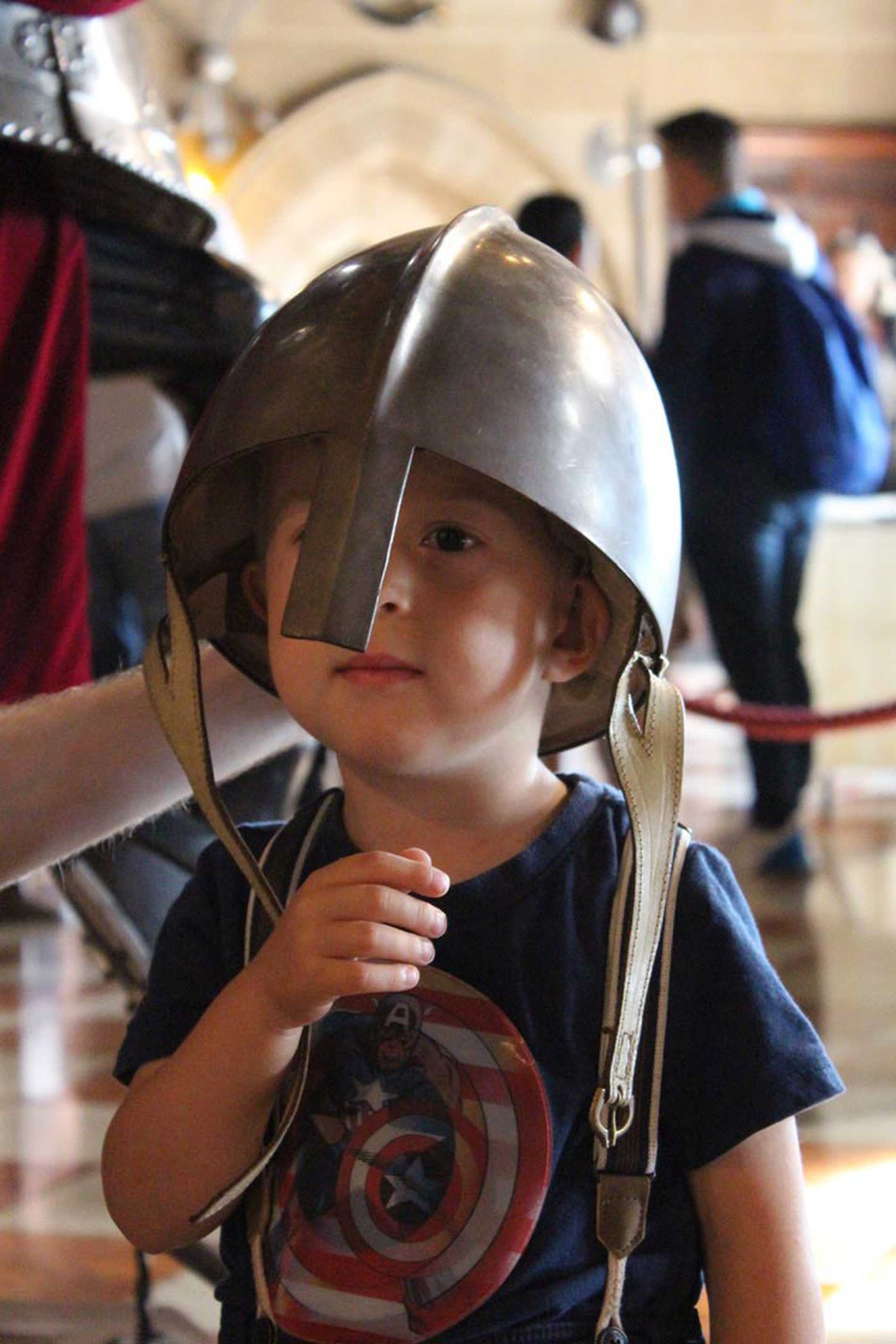 Hunor wearing a knight's helmet that's a little too large for him.