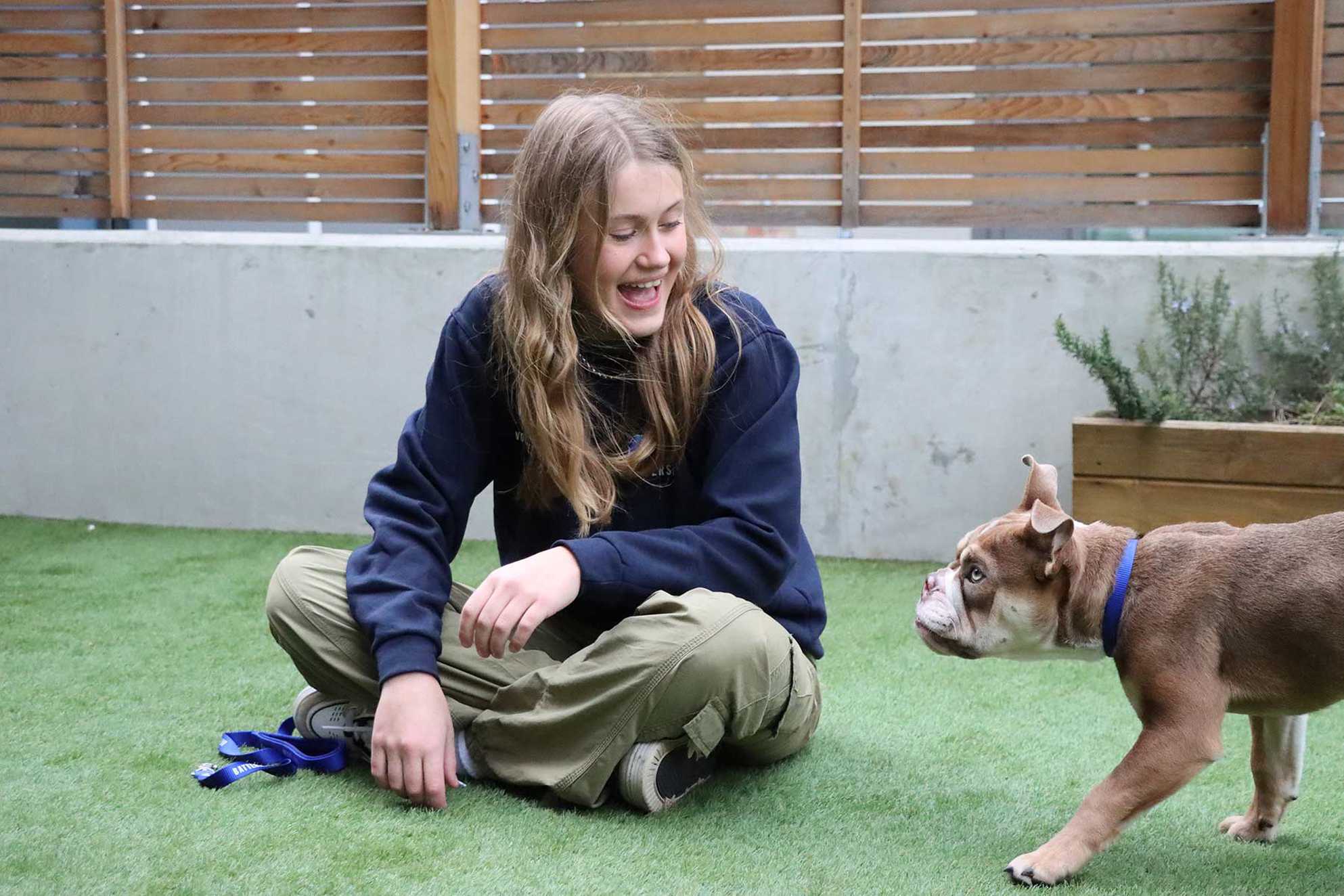 Leila smiling as she meets one of the rescue dogs, Mr Big.