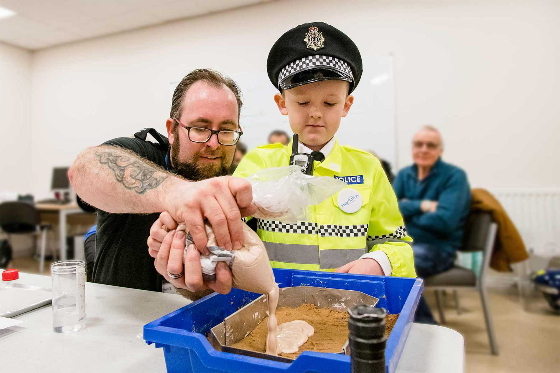 Allan being shown how to take a cast of a footprint.