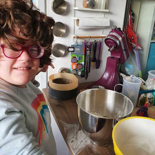 Dakota in front of an array of cooking bowls and dishes.