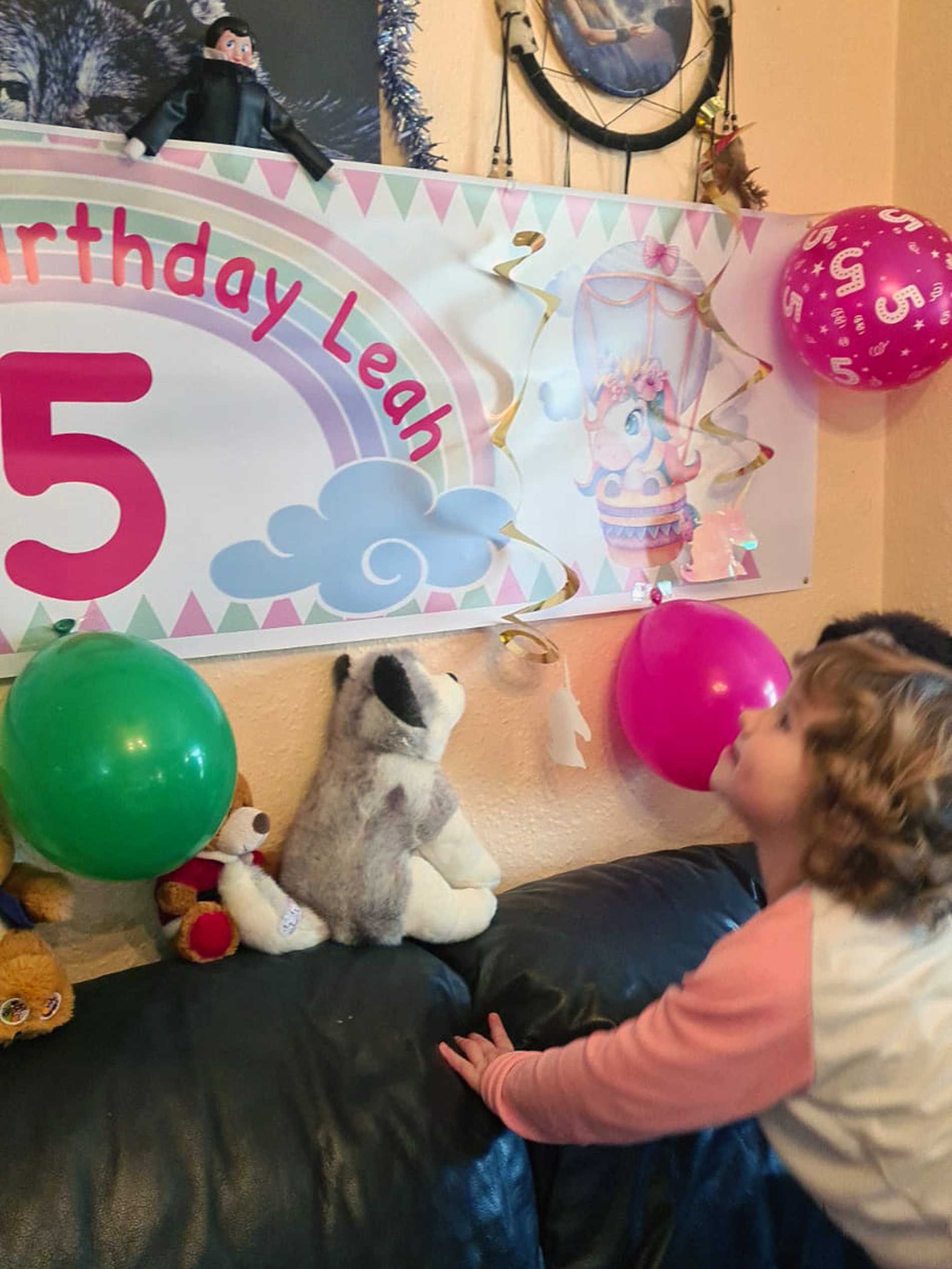 Leah leaning on the sofa, looking up at her 'happy birthday' banner.