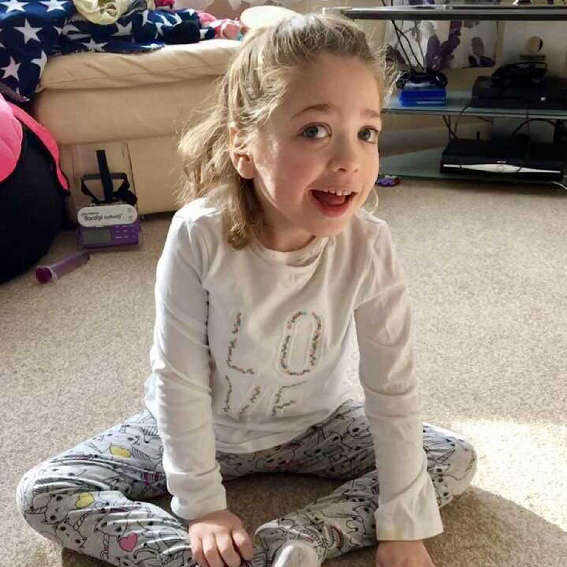 Aubree at home in her pyjamas, with a big smile on her face