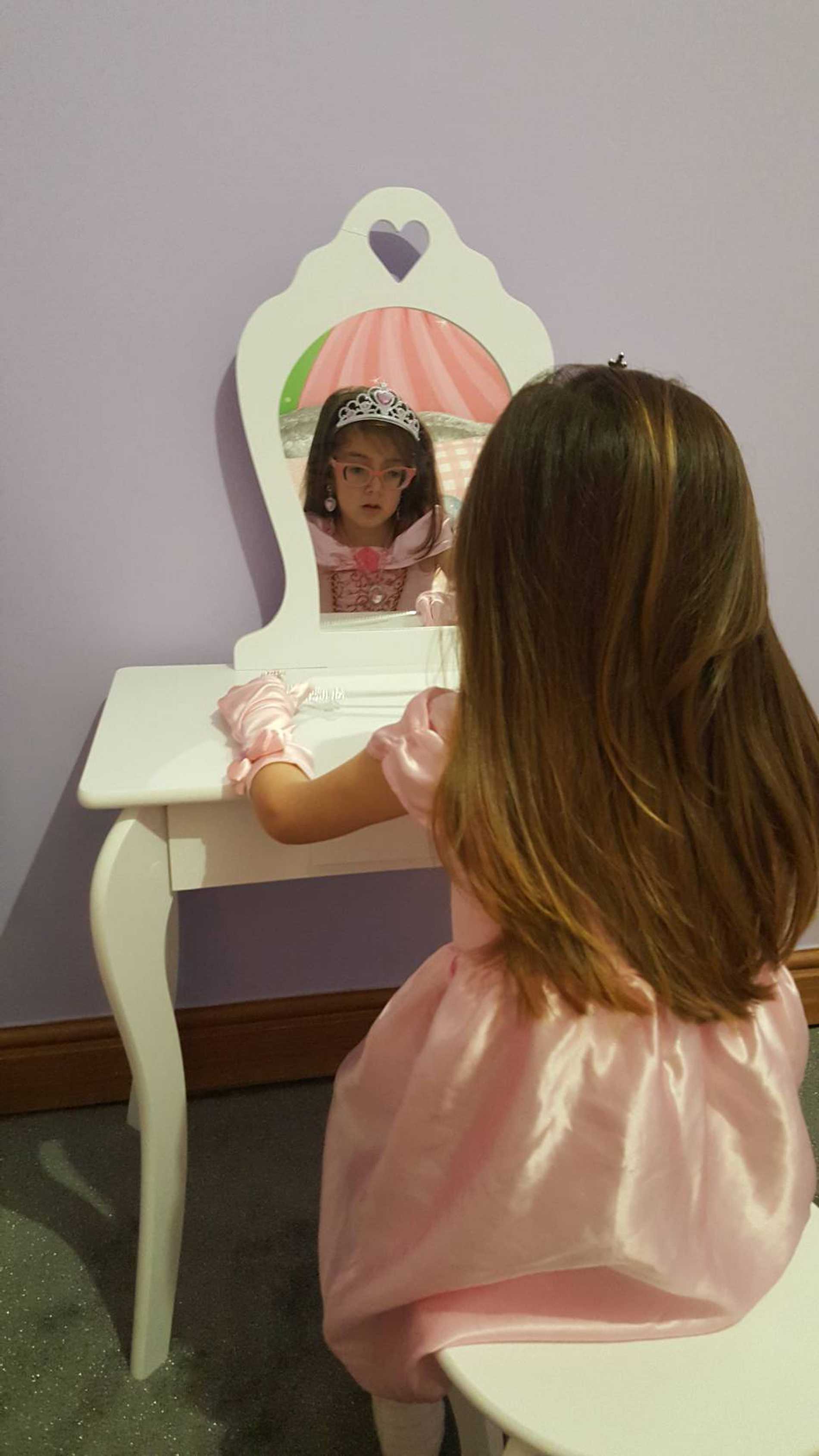 Smiling wish child, Tiara in her princess-themed bedroom.