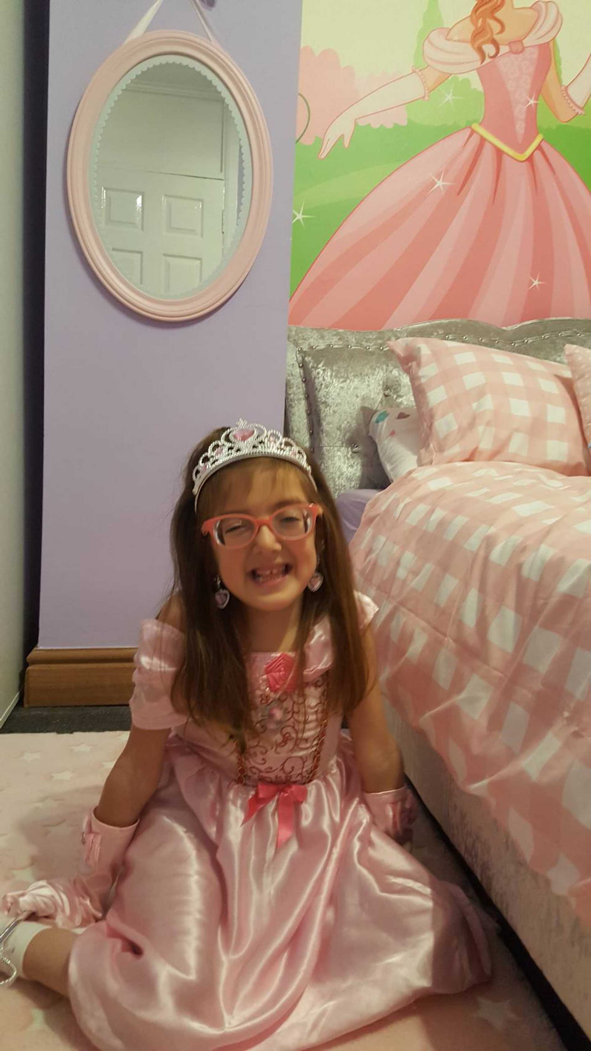 Smiling wish child, Tiara in her princess-themed bedroom.