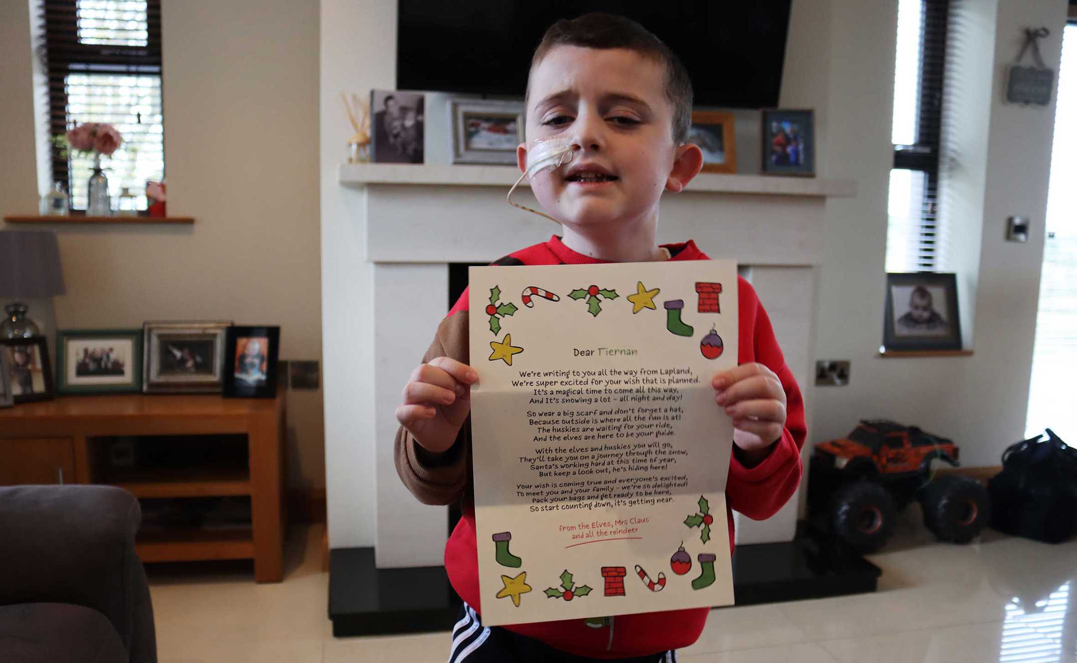 Tiernan holding up the letter telling him his wish to go to Lapland was coming true.