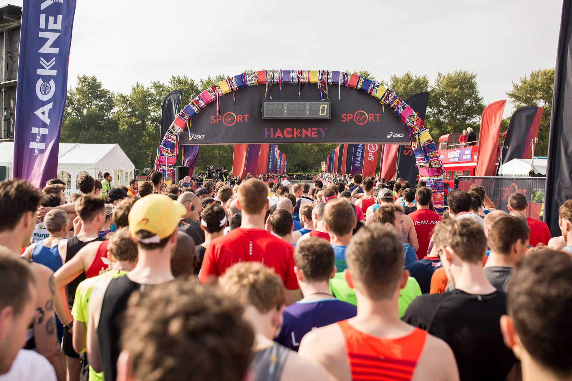 A crowd of runners wait eagerly at the start line for the Hackney Half Marathon to commence.