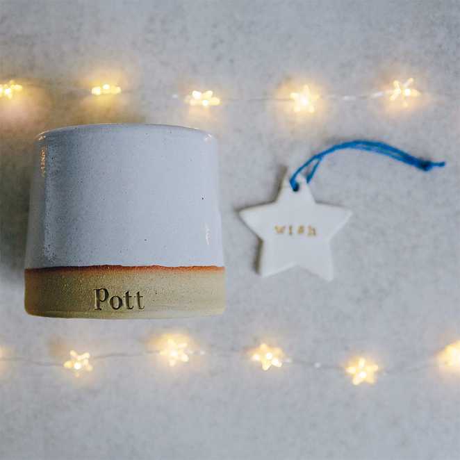 A Pott candle and porcelain star with a blue ribbon.