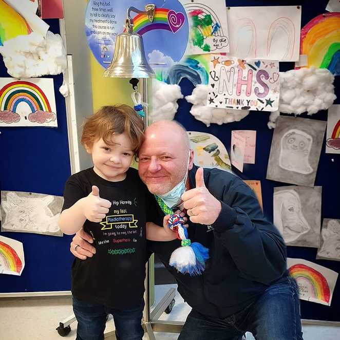 Aaron and his dad ringing the end of treatment bell after his first round of treatment, prior to his relapse.