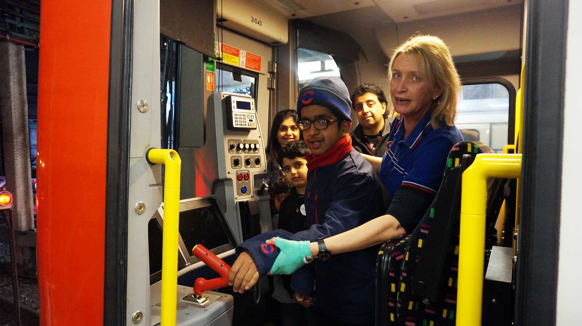 Krish being shown the controls of an underground train by driver, Leslie.