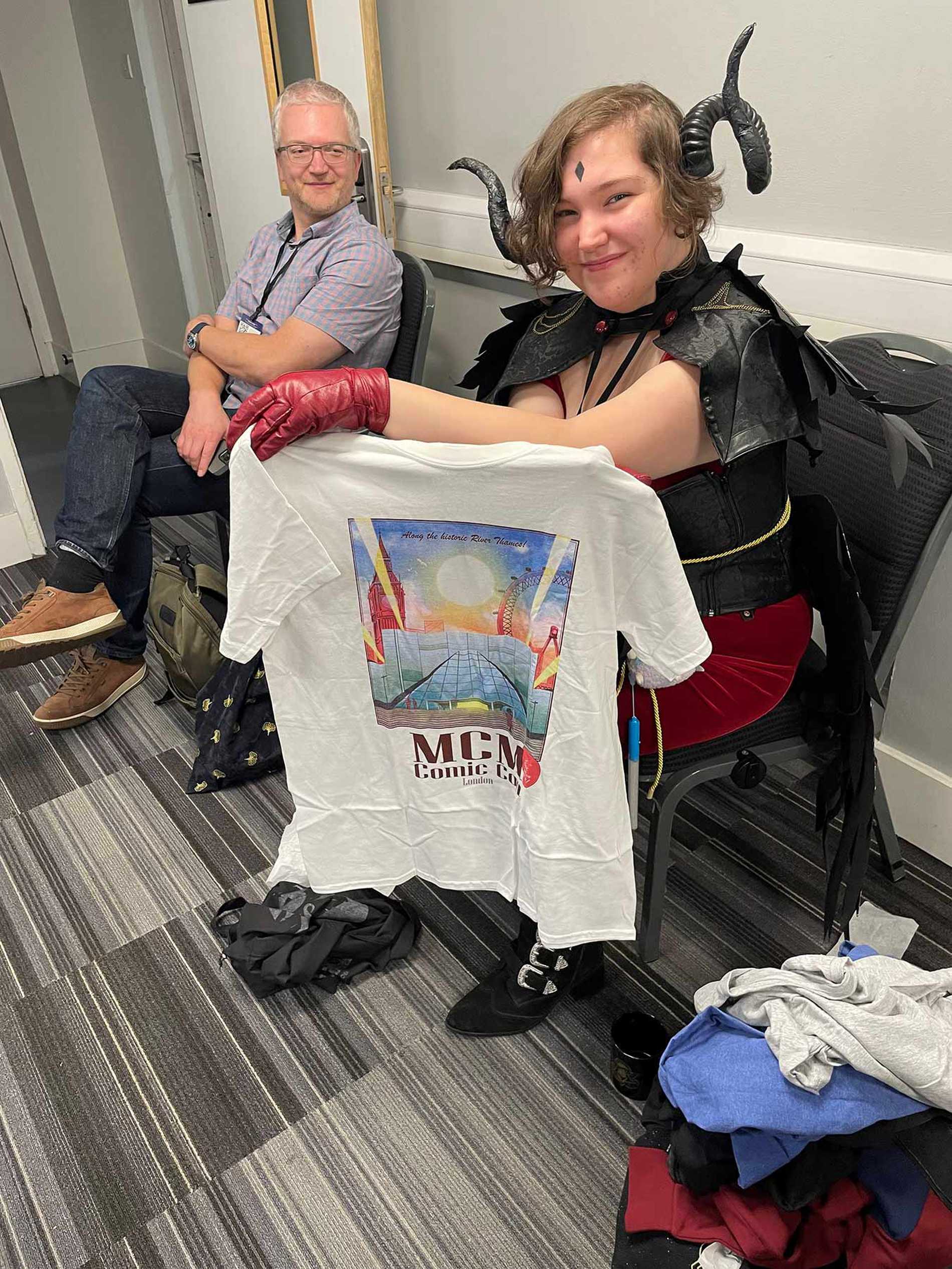 Elsie holding up an MCM Comic Con t-shirt