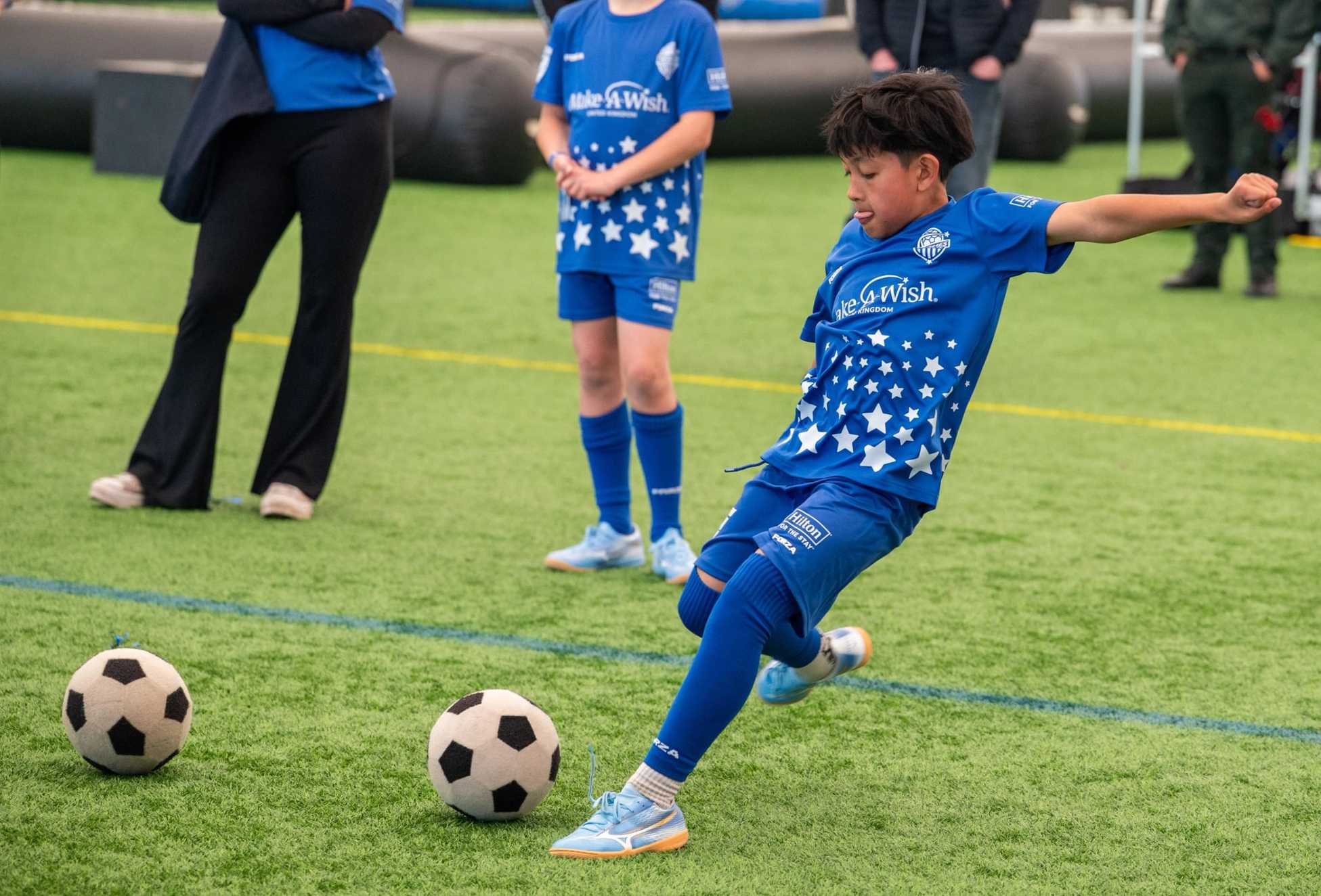 Liam, dressed in blue Wishes United kit is just about to strike a football hard