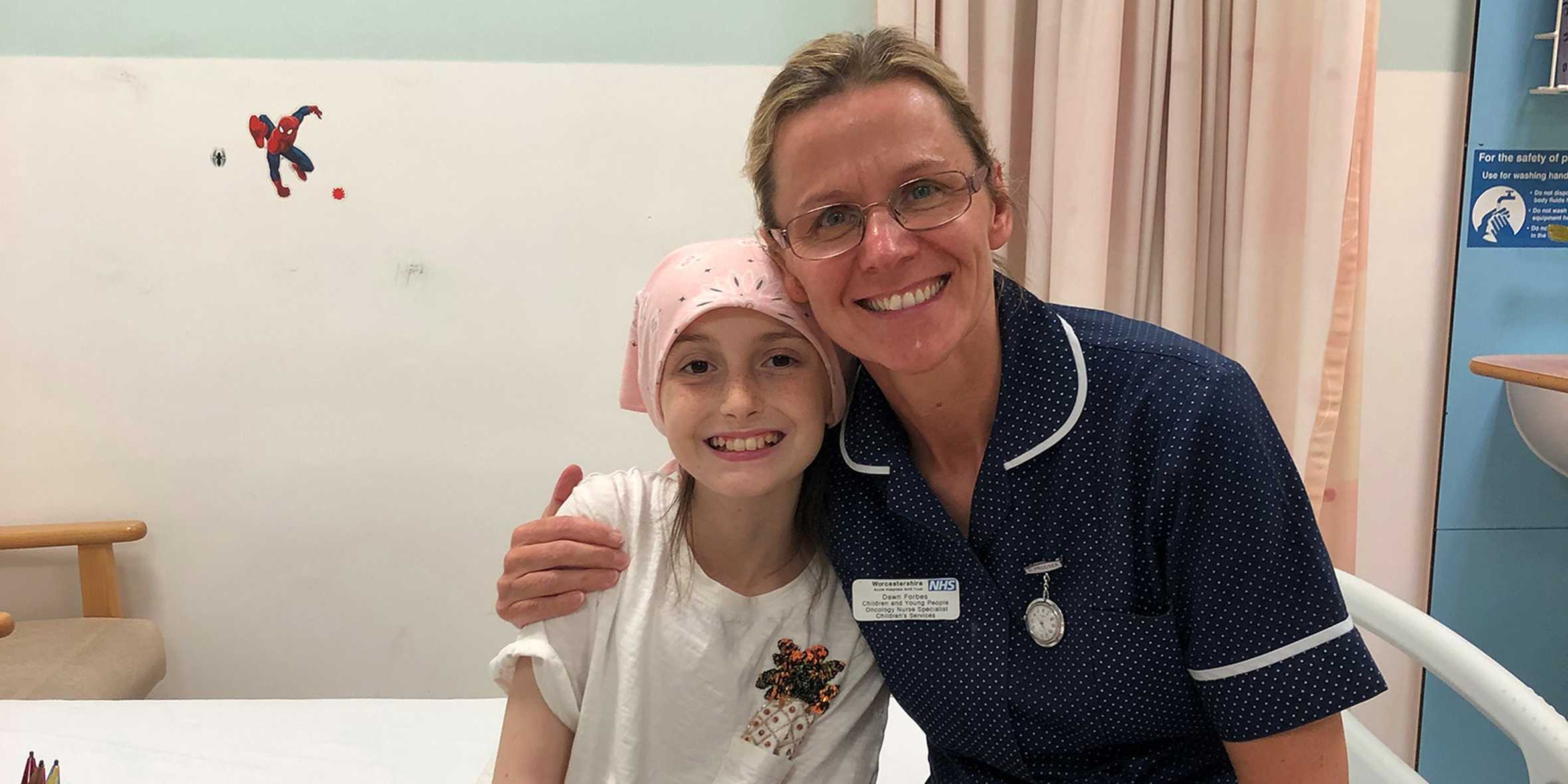 Dawn with her arm around a child in her care while working in her role as a nurse.