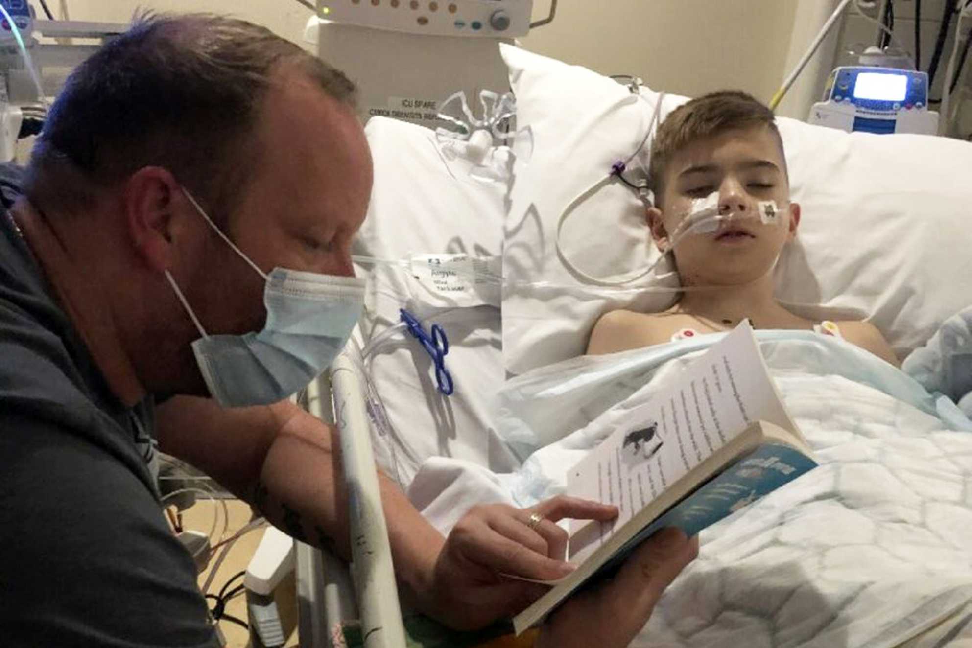 Connor's dad reading to him at his bedside, during his hospital stay.