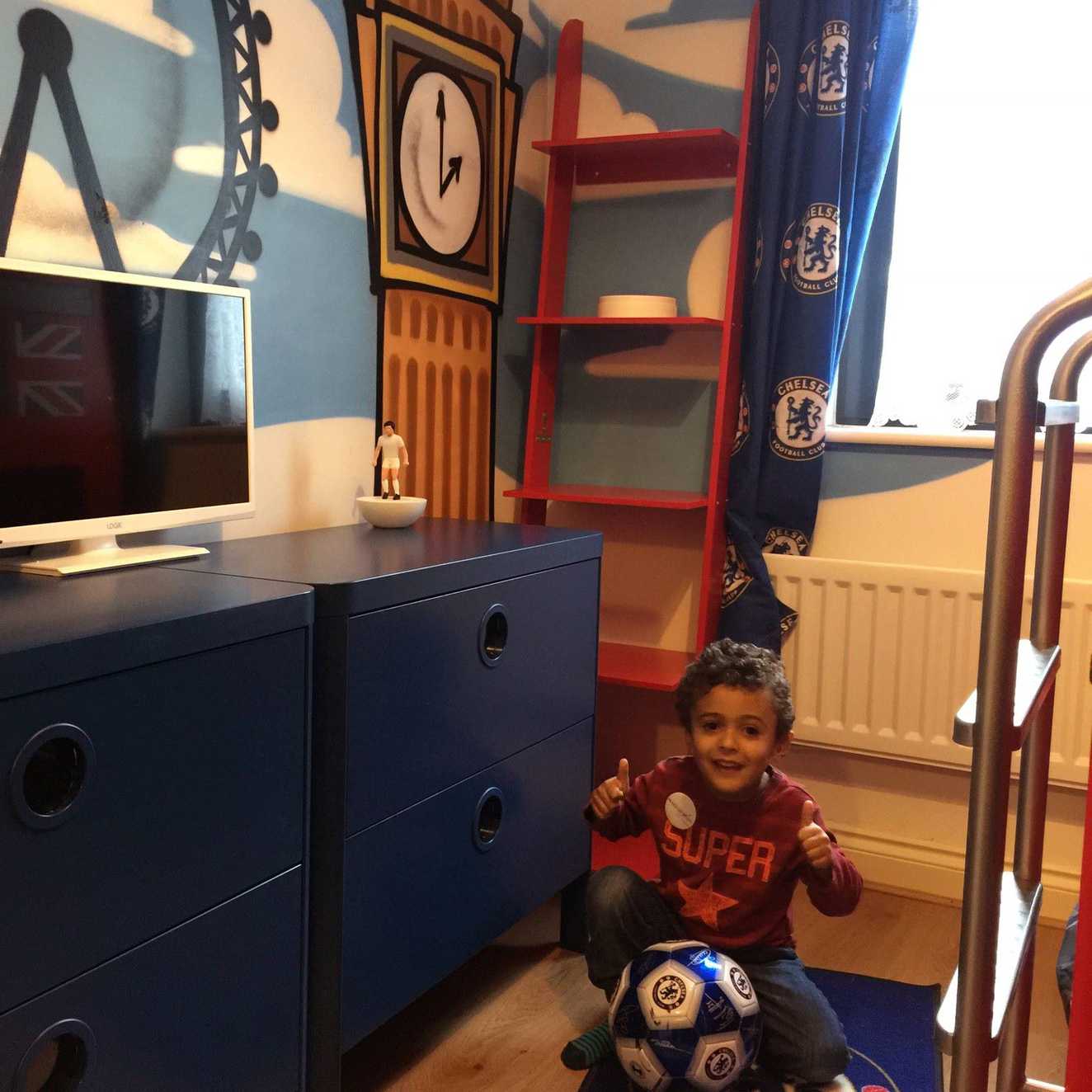 Wish Child Mohammad in his new bedroom smiling and giving a thumbs up to the camera