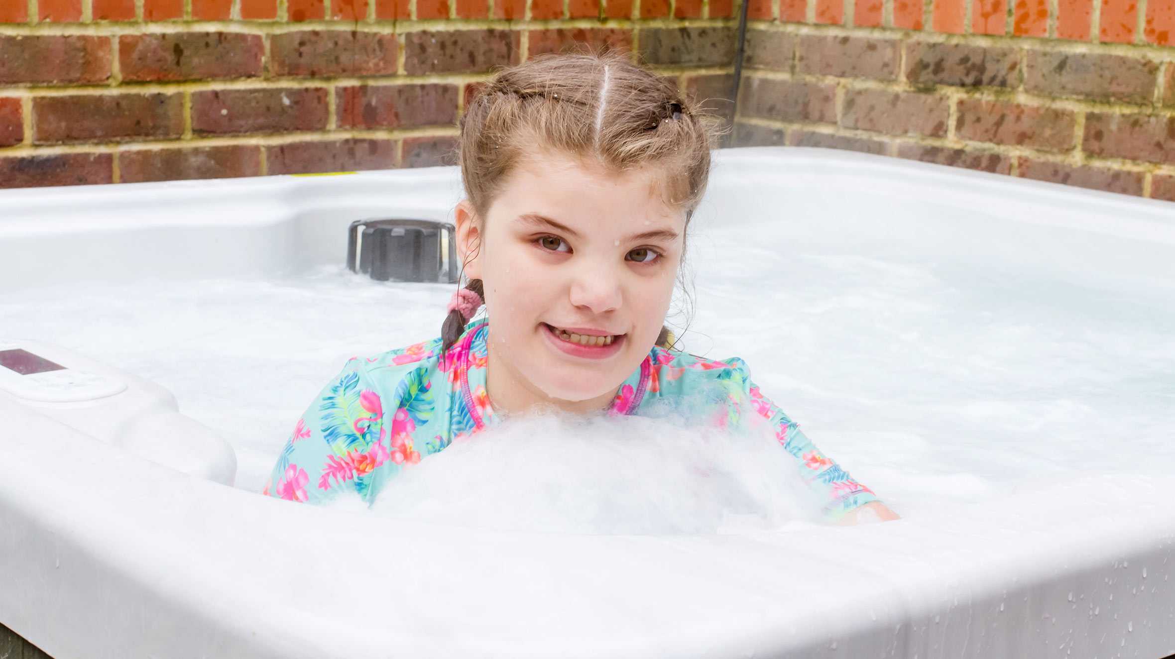 Wish child, Gracie, smiling in her new hot tub.